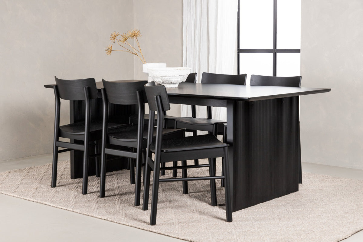 Esszimmerset aus rechteckigem MDF-Tisch in Rauchschwarz mit sechs Limhamn-Stühlen, beiger Samtbezug, muschelförmige Rückenlehne, schwarze Metallbeine.