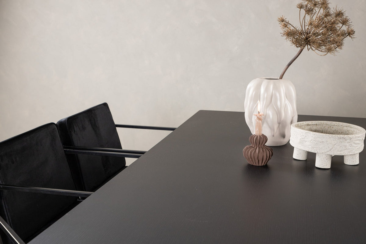 Esszimmerset aus rechteckigem MDF-Tisch in Rauchschwarz mit sechs Limhamn-Stühlen, beiger Samtbezug, muschelförmige Rückenlehne, schwarze Metallbeine.