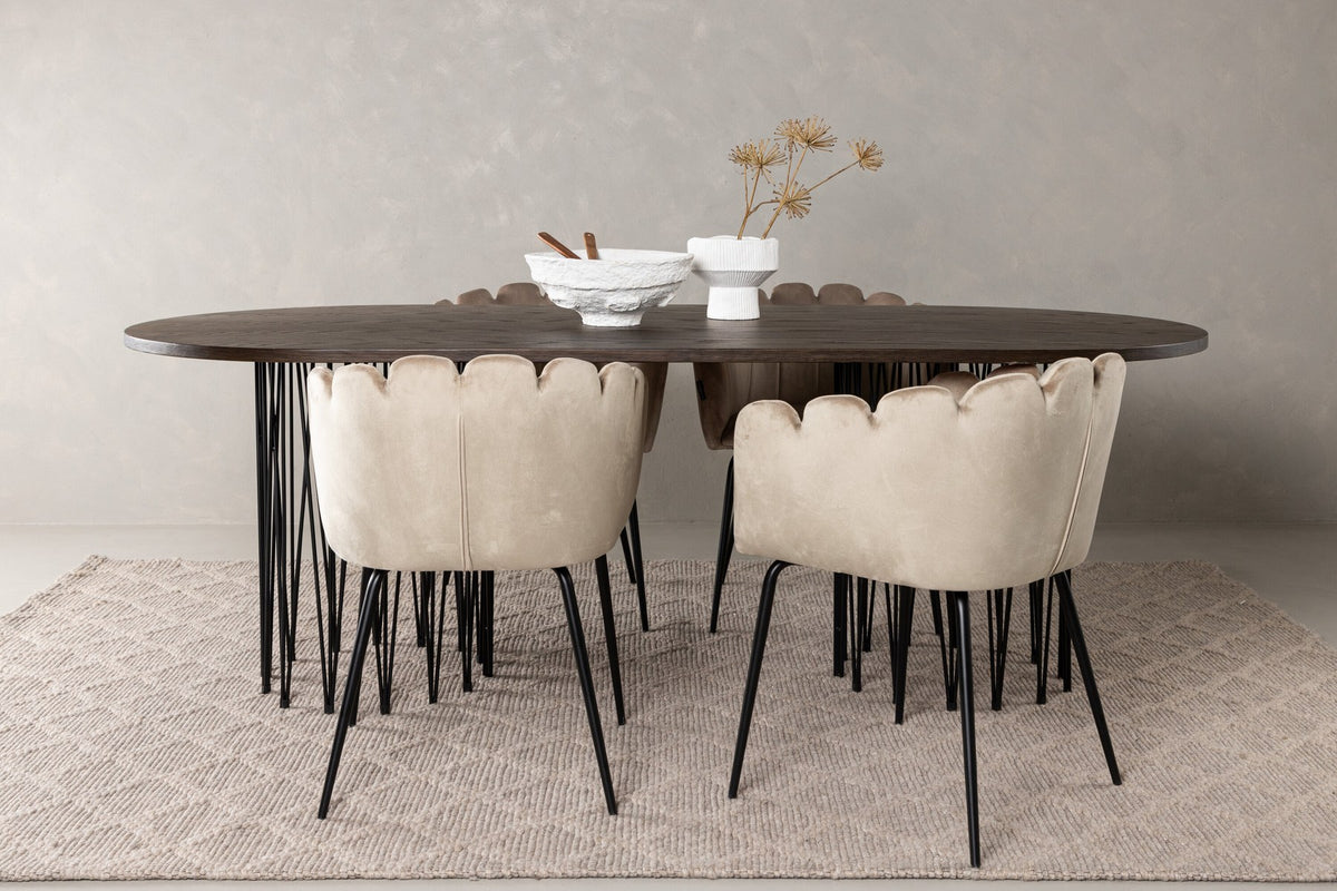 Ovaler Esstisch mit Tischplatte aus MDF mit Mocca-Furnier und schwarzem Metallgestell, umgeben von vier Limhamn-Stühlen mit beigem Samtbezug.