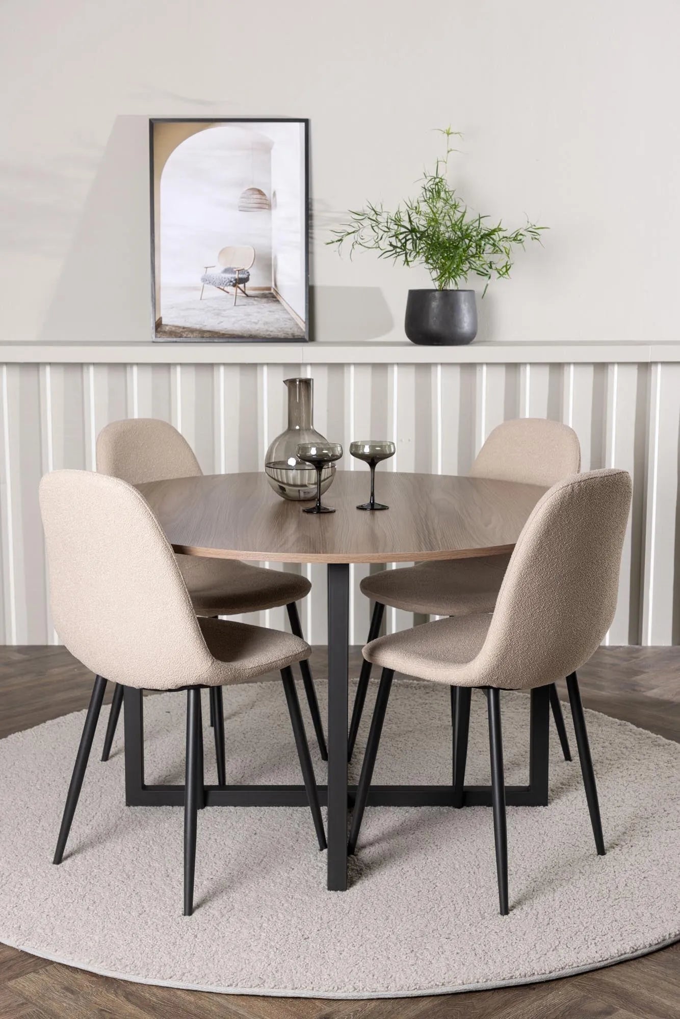Elegantes Esszimmerset im skandinavischen Stil mit rundem Tisch und bequemen Stühlen für stilvolle Dinner.