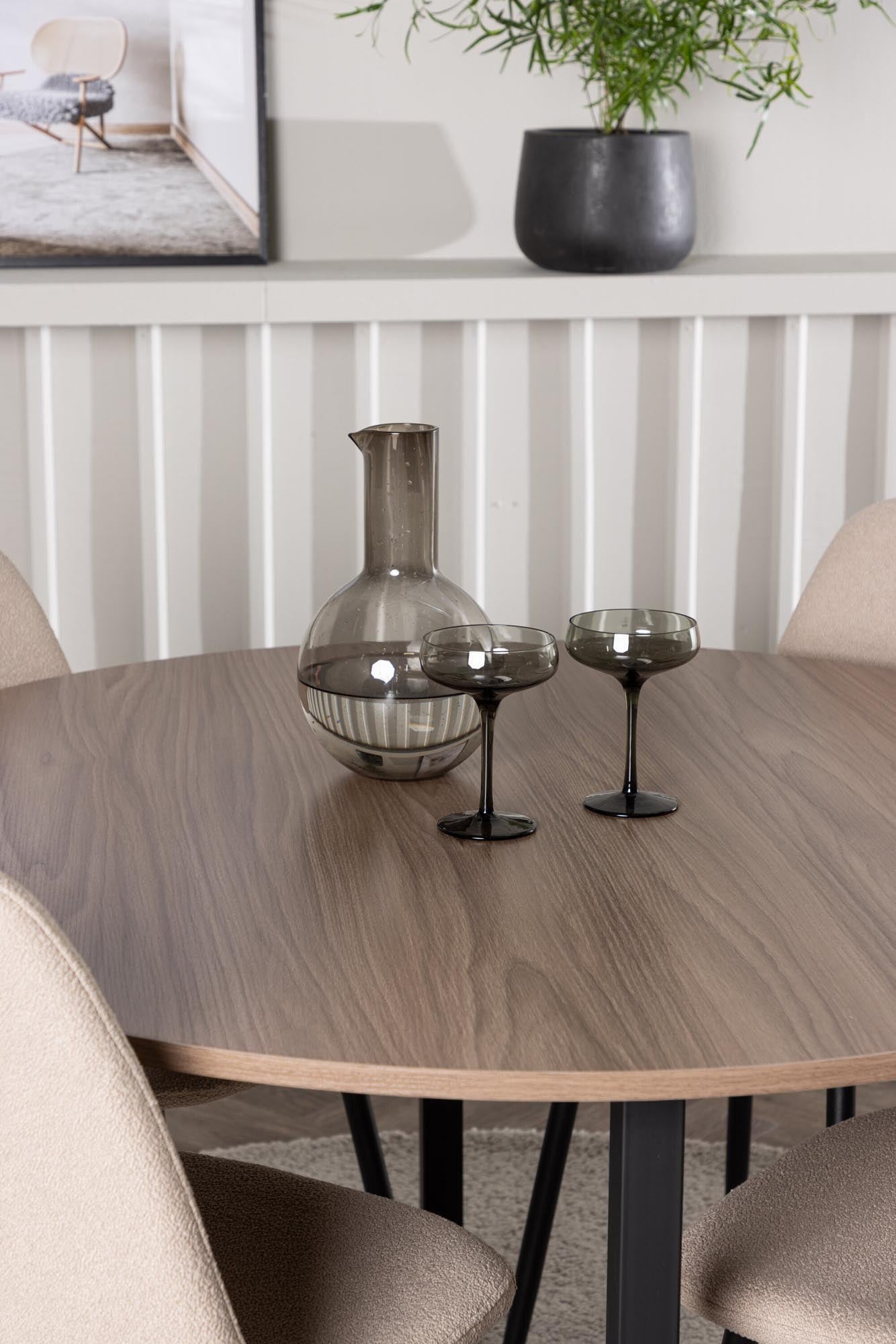 Elegantes Esszimmerset im skandinavischen Stil mit rundem Tisch und bequemen Stühlen für stilvolle Dinner.