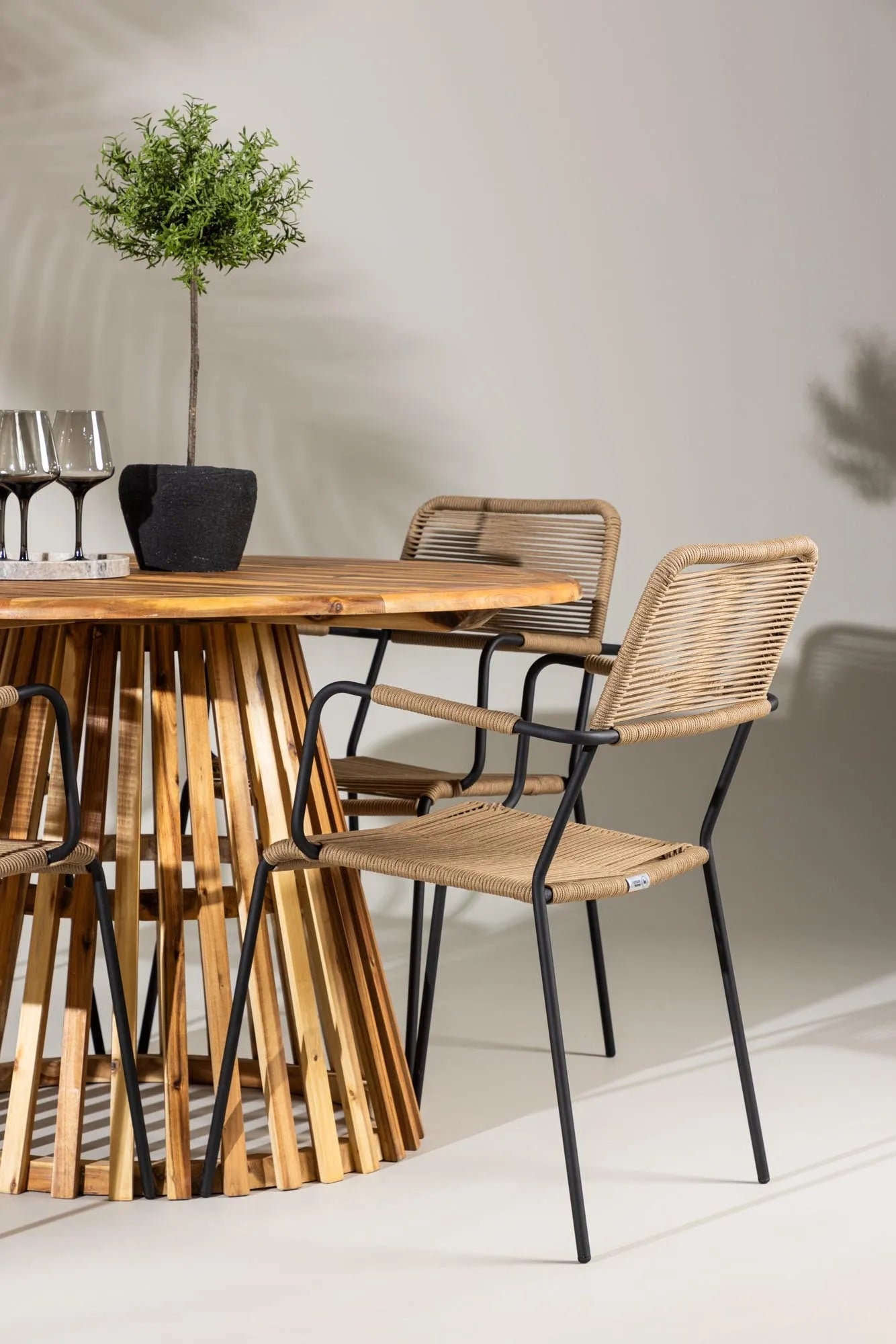 Rundes Gartenset mit modernem Design: Tisch und komfortable Armstühle, perfekt für Garten oder Terrasse.