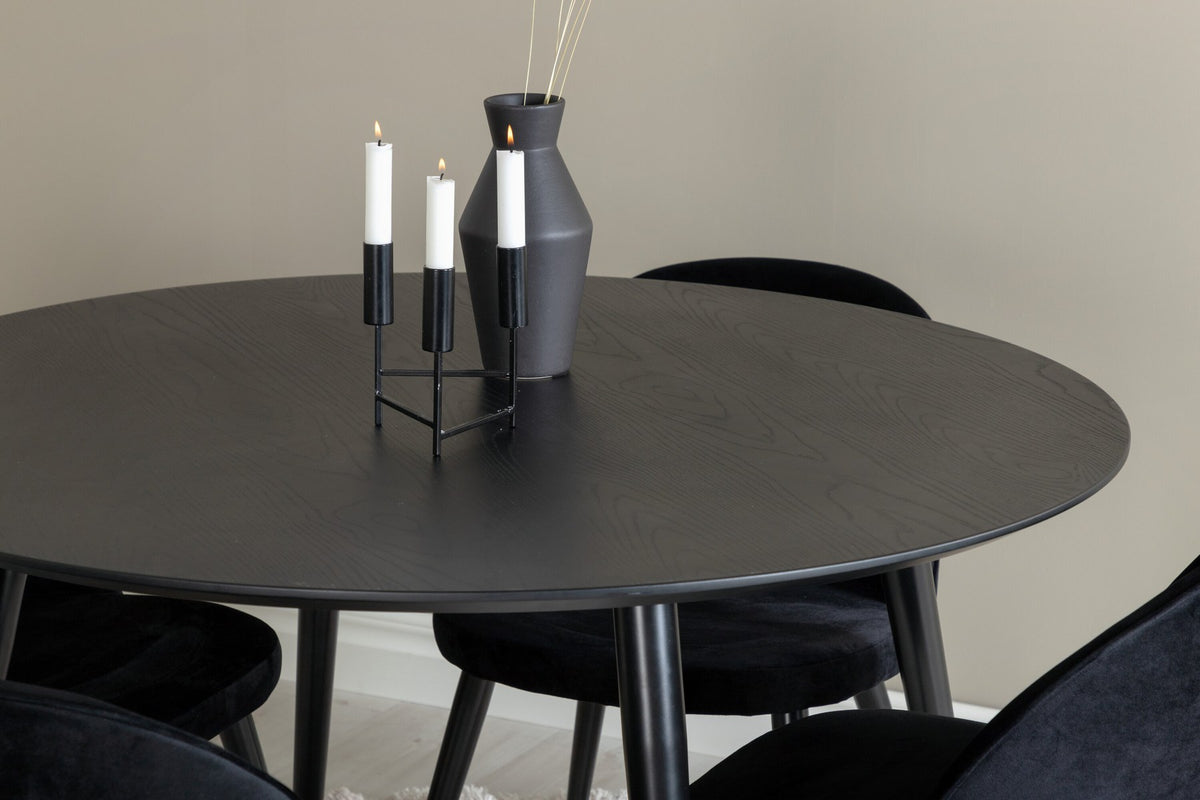 Rundes Dipp Esszimmerset: Esstisch ⌀115 cm mit schwarzem Furnier und schwarzen Beinen, dazu vier Velvet-Stühle mit schwarz-grauem Mikrofaserbezug.