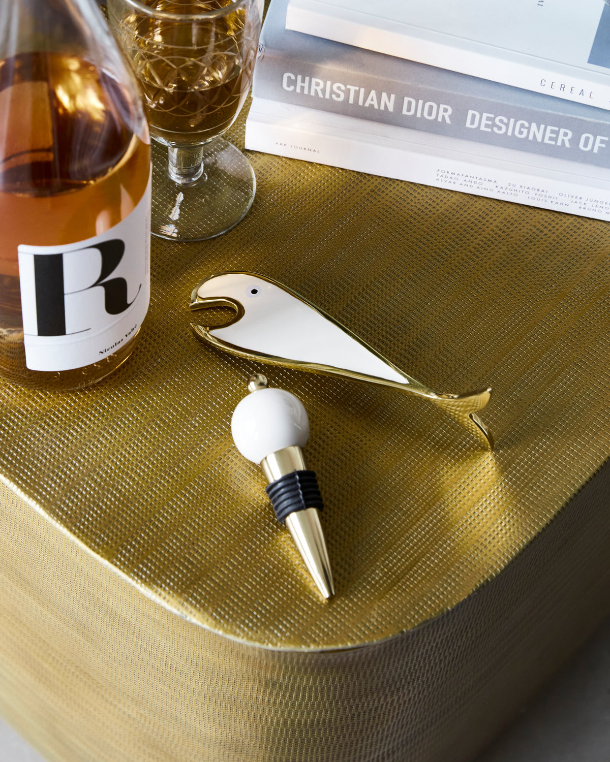 Flaschenöffner in Fischform und Flaschenverschluss aus Aluminium in Gold mit sandfarbenen Details
