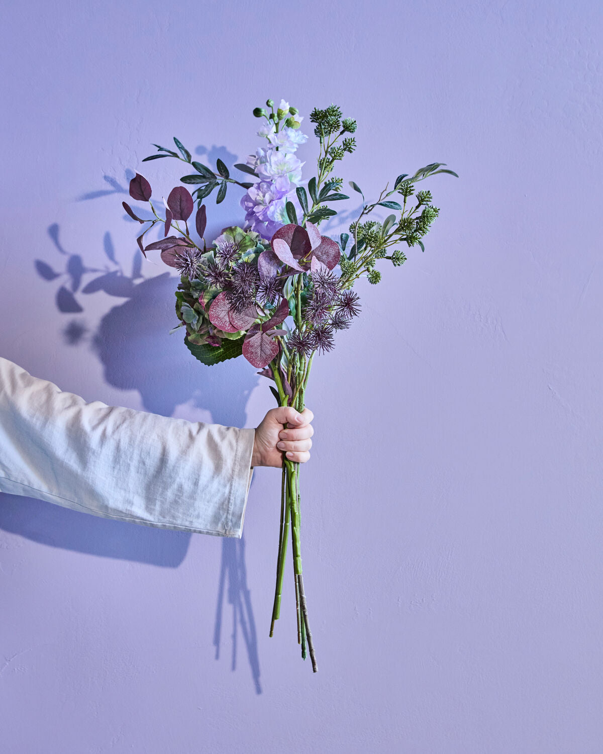 Künstlicher Blumenstrauß in sanften Lila- und Violetttönen, ideal für stilvolle Dekorationselemente in jedem Raum.