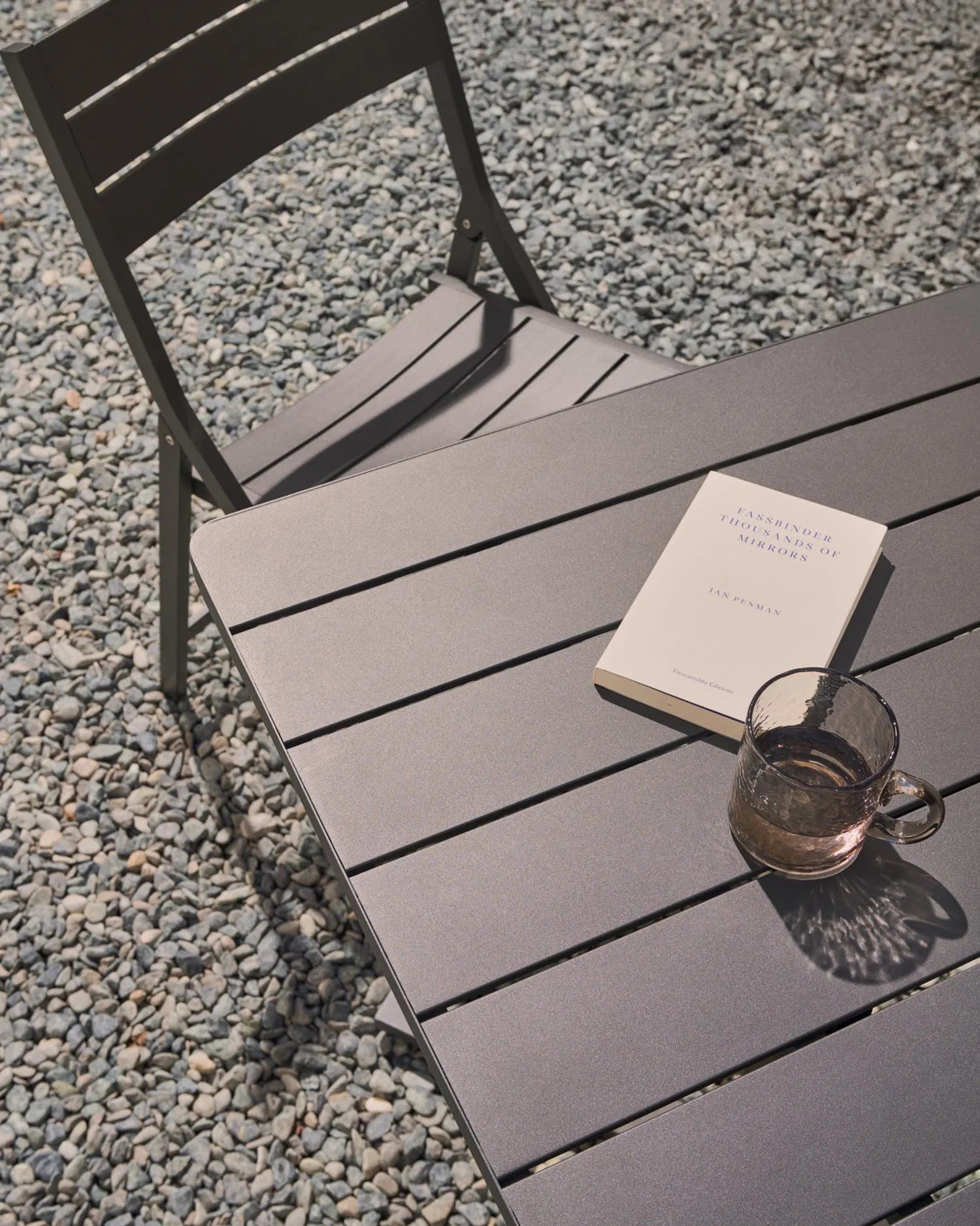 Kompakter, faltbarer Aluminiumtisch in elegantem Dunkelgrau, ideal für stilvolle Outdoor-Mahlzeiten auf Balkon oder Terrasse.