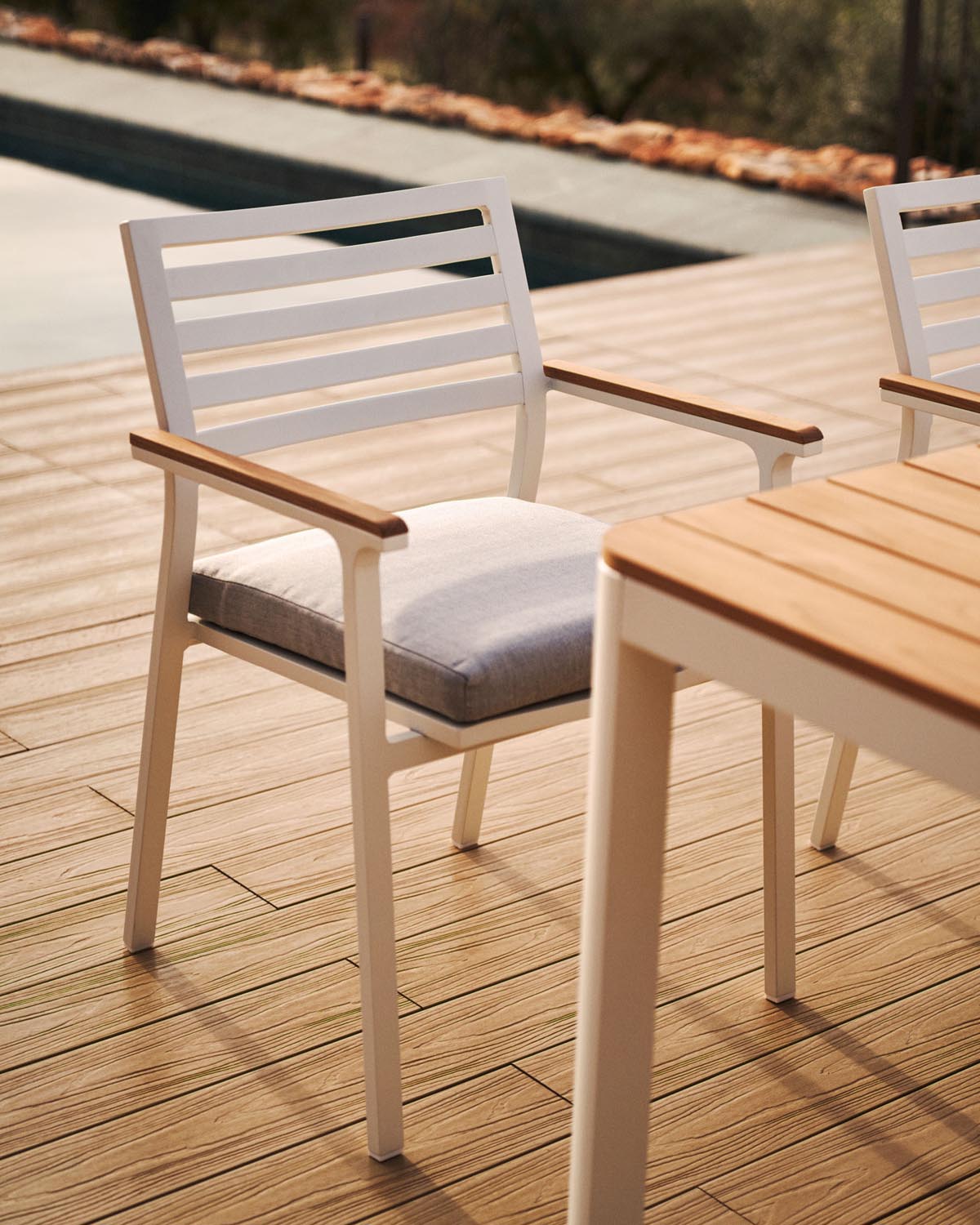 Eleganter Gartenstuhl aus Aluminium mit Teak-Armlehnen, stapelbar.
