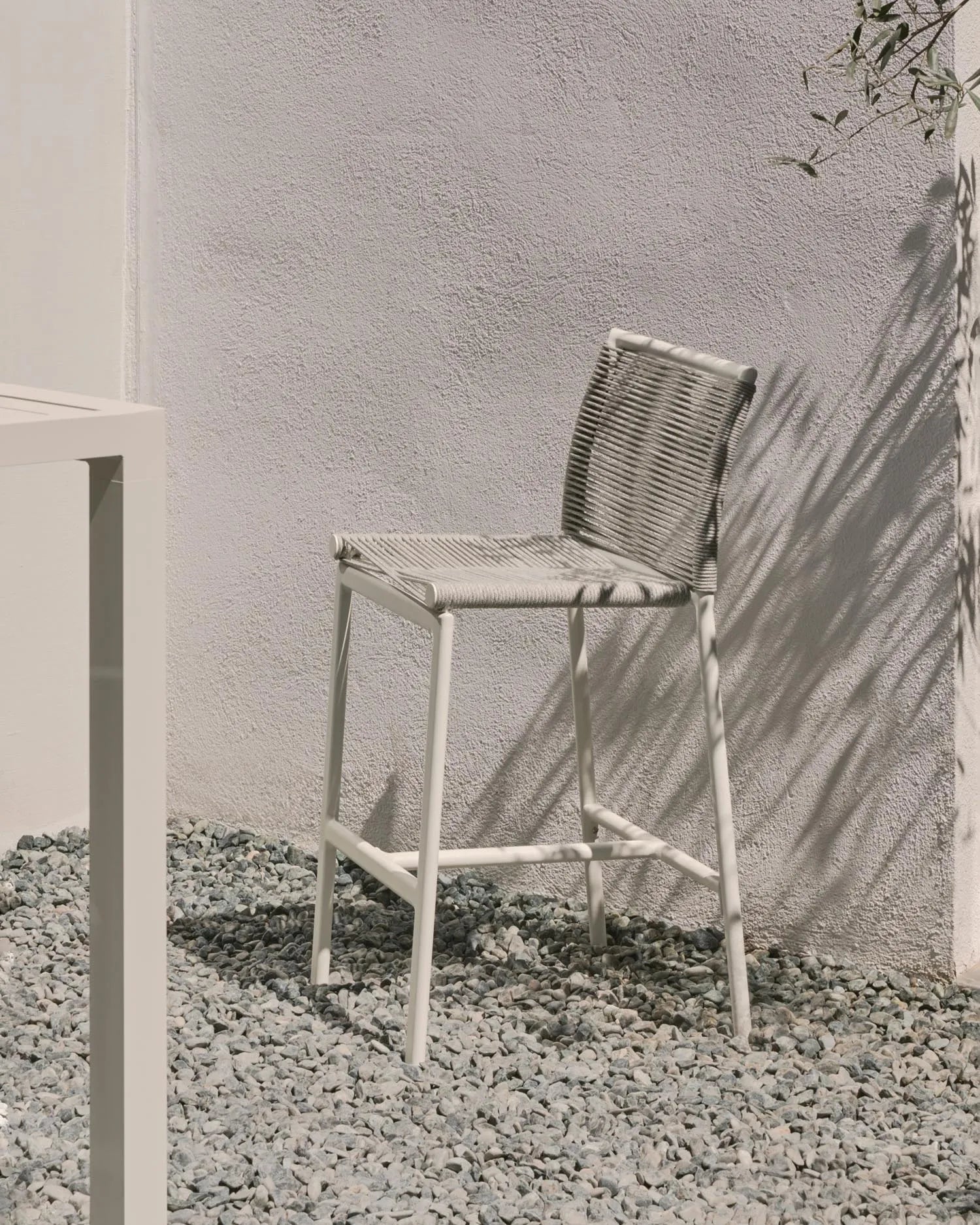 Der Culip Outdoor-Hocker vereint modernes Design mit Komfort: weißes Aluminium und geflochtenes Seil für stilvolle Entspannung im Freien.