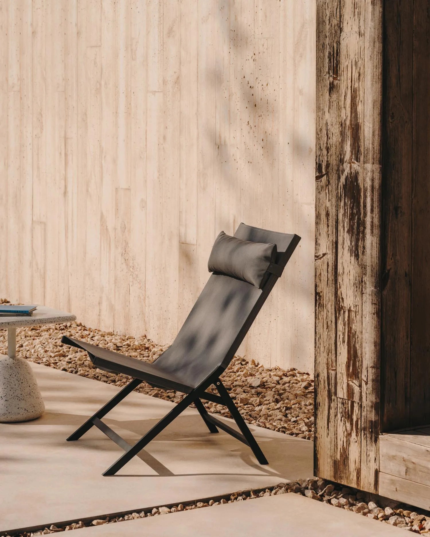 Eleganter Klappstuhl aus Aluminium mit dunkelgrauem Finish, Texteline-Sitz und Holzdetails. Ideal für stilvolle Außenbereiche.