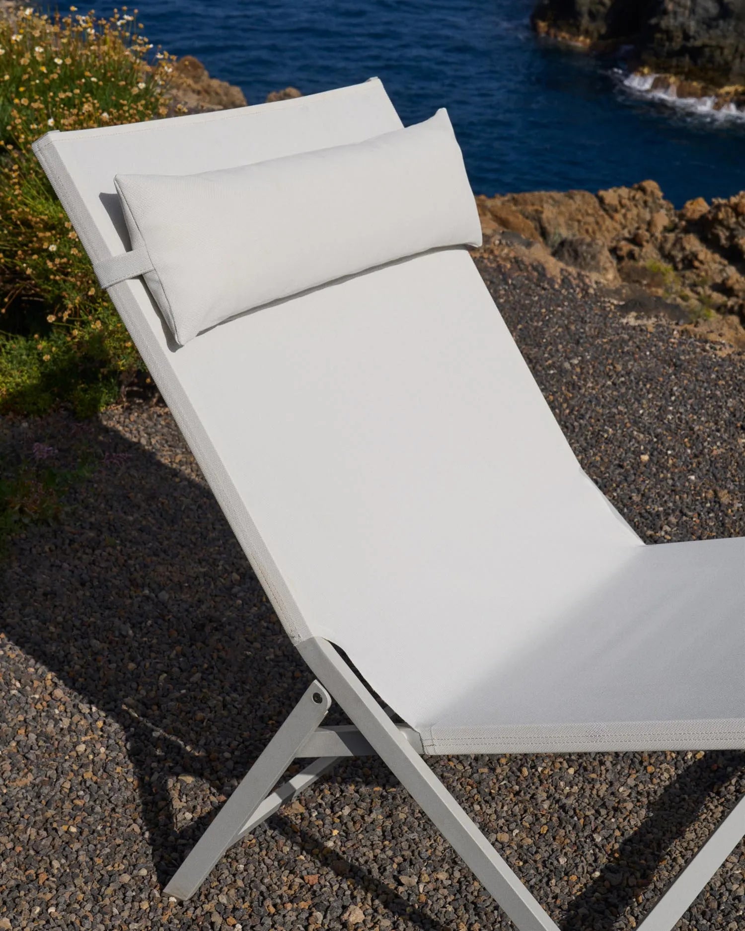 Eleganter Klappstuhl aus Aluminium mit weißem Finish, atmungsaktivem Texteline-Sitz und platzsparendem Design für stilvolle Außenbereiche.