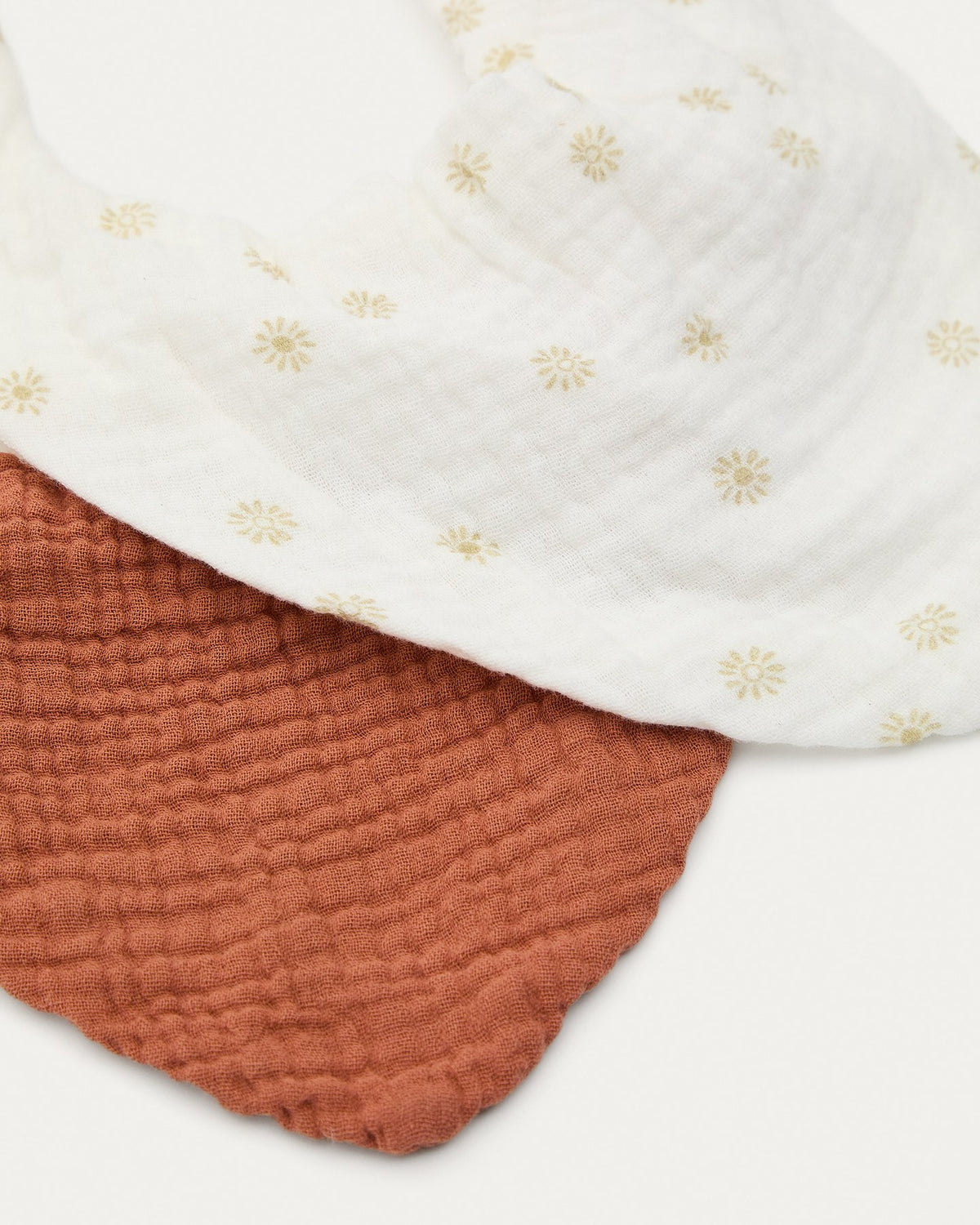 Zwei Baby-Halstücher aus 100% Baumwolle in Terrakotta mit Sonnenmuster, gefaltet nebeneinander liegend, Set Olna von Kave Home.