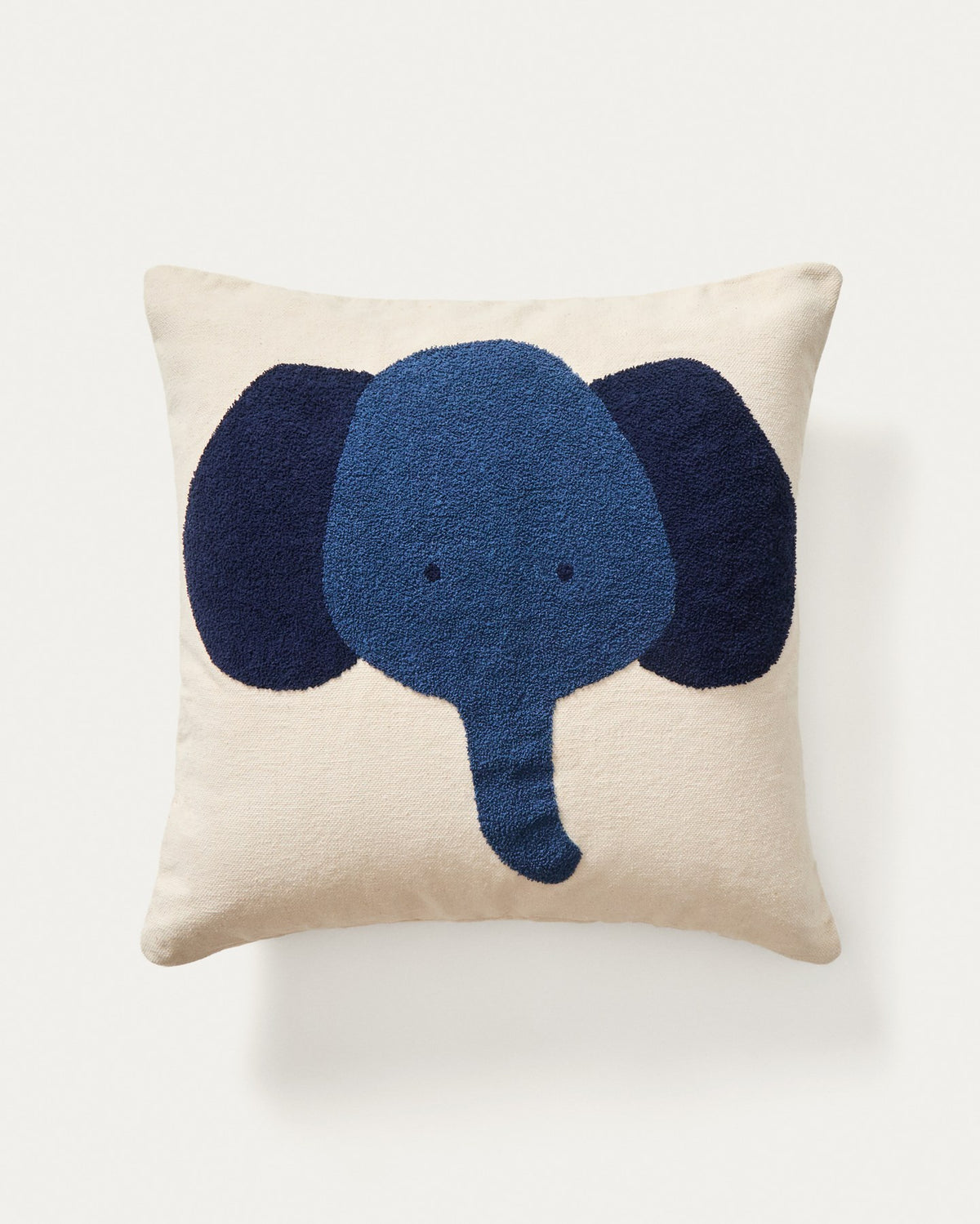 Beigefarbene Bodenkissenhülle aus Baumwolle mit aufgesticktem blauem Elefantenmotiv, quadratische Form, 70 x 70 cm.