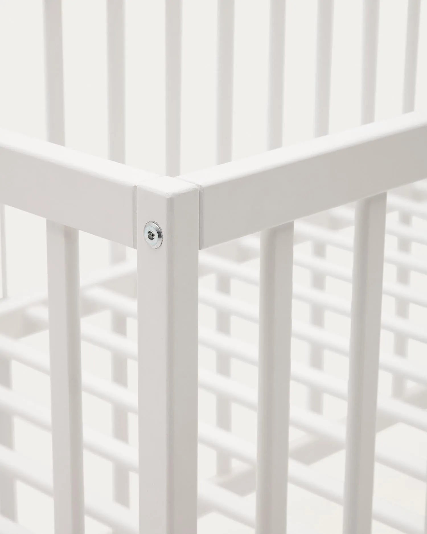 Elegantes Gitterbett aus massiver Buche mit weißem Finish, anpassbarer Matratzenhöhe, ideal für Babys und Kleinkinder.