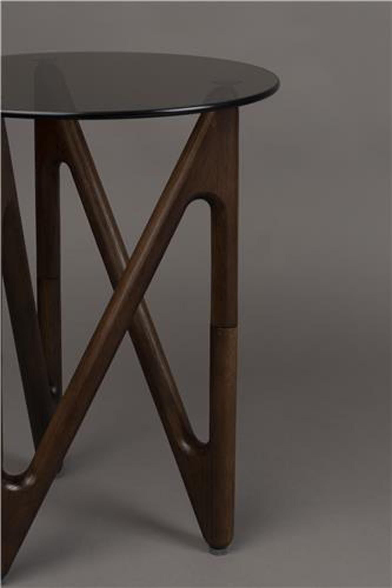 Der stilvolle Beistelltisch Naia von Dutchbone vereint dunkles Glas und Eichenholz für ein modernes, elegantes Design. Ideal für jedes Zuhause.
