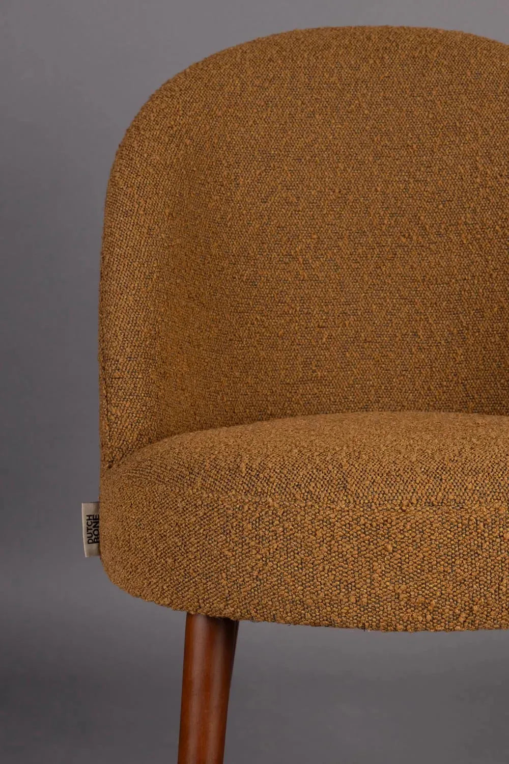 Eleganter Boucle-Stuhl in Ocker für modernes Wohndesign von Dutchbone.