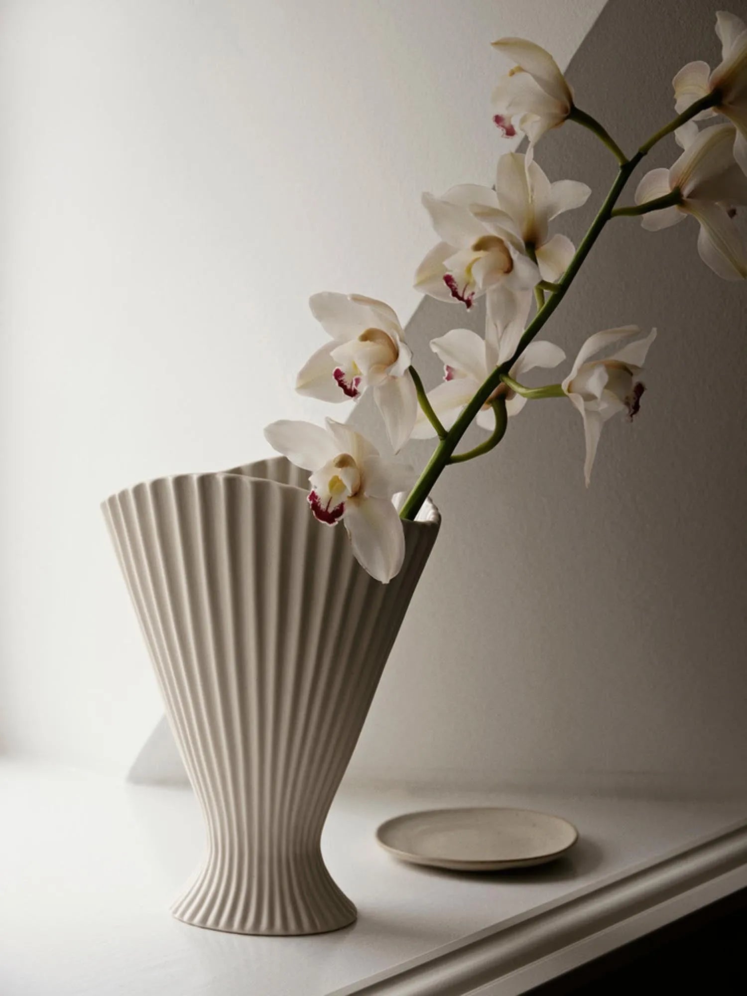 Elegante, skulpturale Keramikvase in Off-White, inspiriert von Springbrunnen, mit matter Außenseite und glasierter Innenseite.
