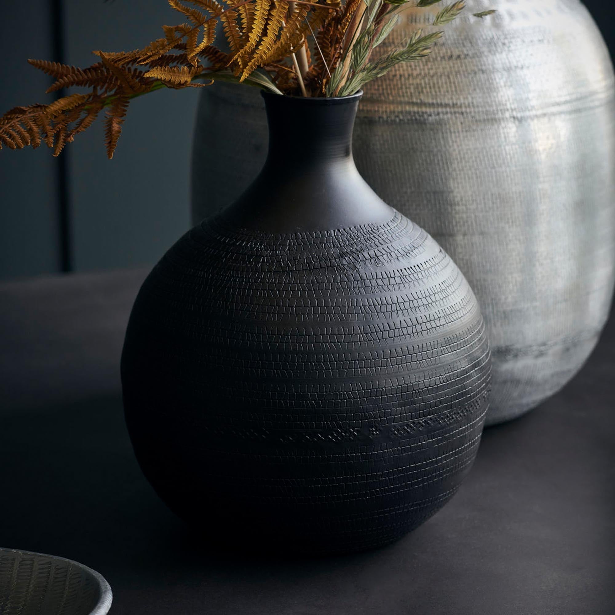 Stilvolle Vase aus Aluminium in Braun mit handgestempeltem Muster, perfekt für Blumen auf Tisch oder Sideboard.