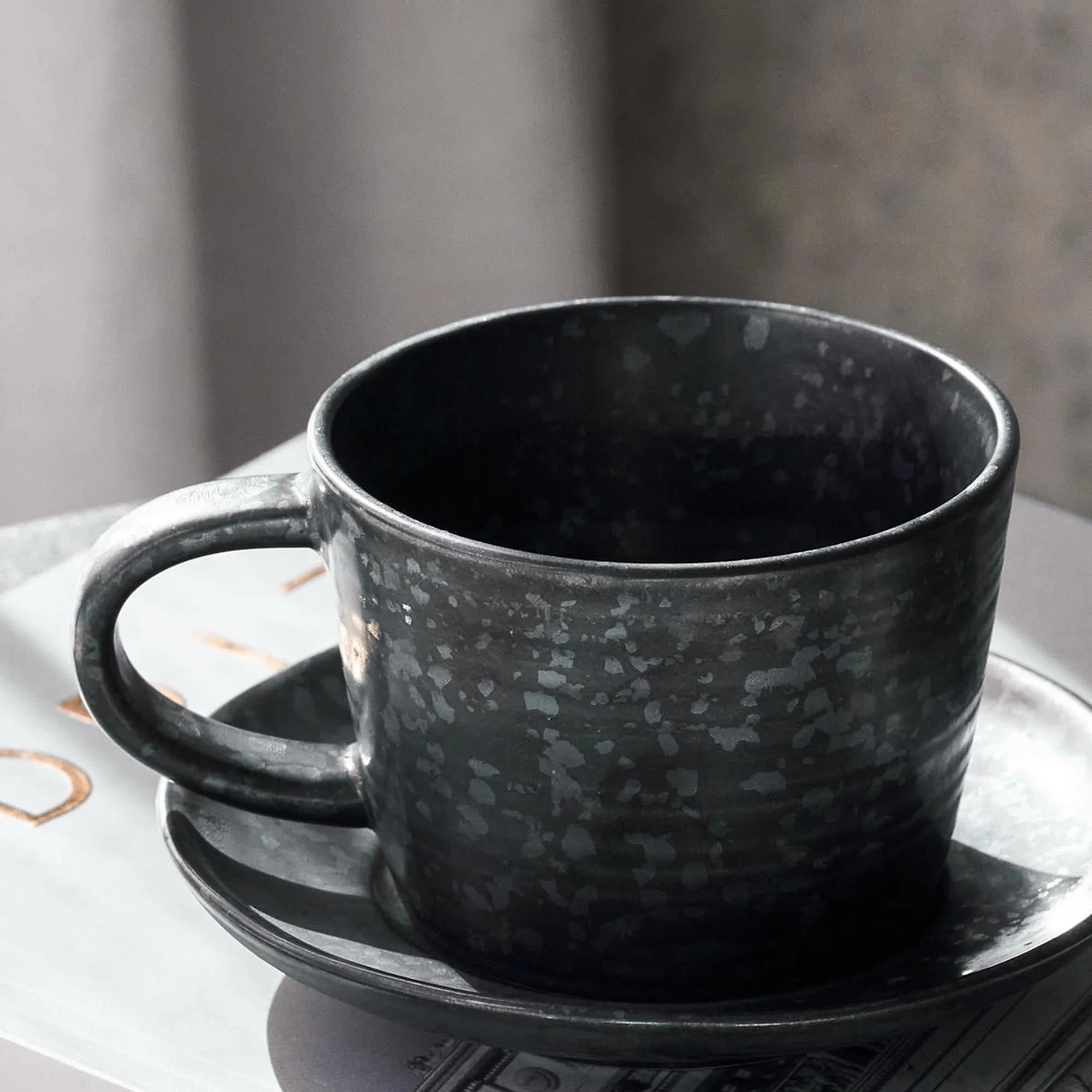 Stilvolle Kaffeetasse mit Untertasse von House Doctor, Schwarz/Braun.