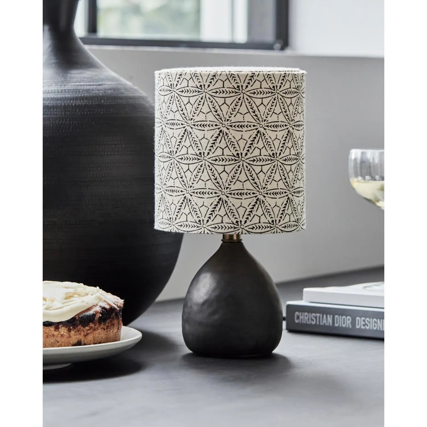 Die HDFlores Tischleuchte von House Doctor vereint handbedrucktes Leinen und schwarze Eisenbasis zu einem eleganten, vielseitigen Design.
