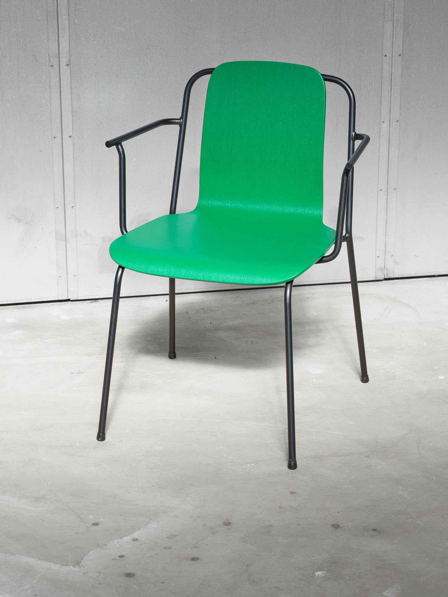 Der Studio Armlehnstuhl von Normann Copenhagen besticht durch sein grafisches Design mit schlankem Stahlrahmen und geformter Schale, ideal für vielseitige Räume.