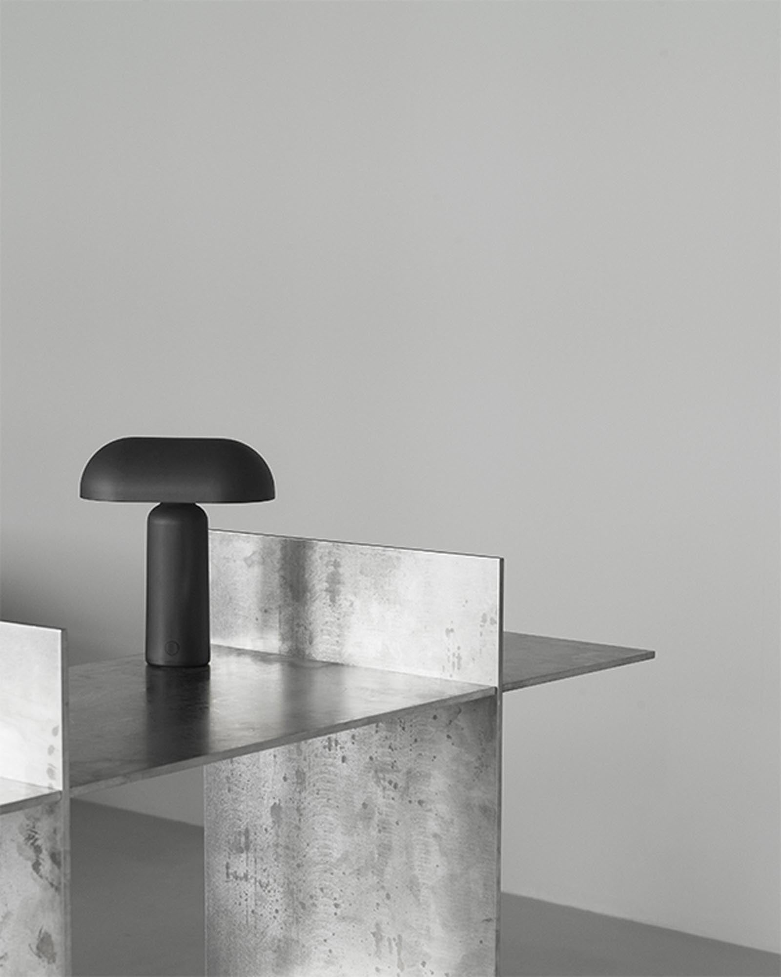 Entdecken Sie die elegante Porta Tischlampe Schwarz von Normann Copenhagen – eine tragbare Leuchte, die Stil und Funktionalität vereint.