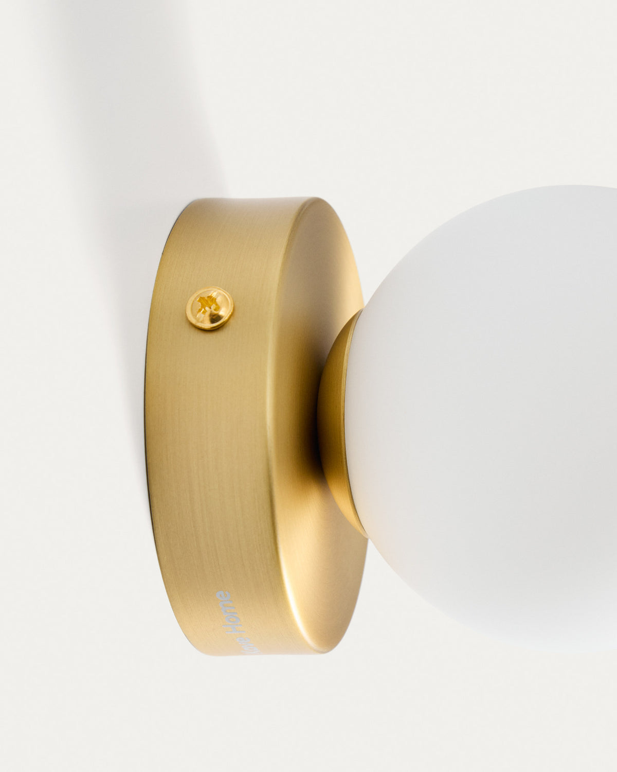 Wandleuchte Brisia aus Metall mit gebürstetem Messing-Finish und einer mattierten Glaskugel Ø 8 cm in Gold präsentiert im Onlineshop von KAQTU Design AG. Wandleuchte ist von Kave Home