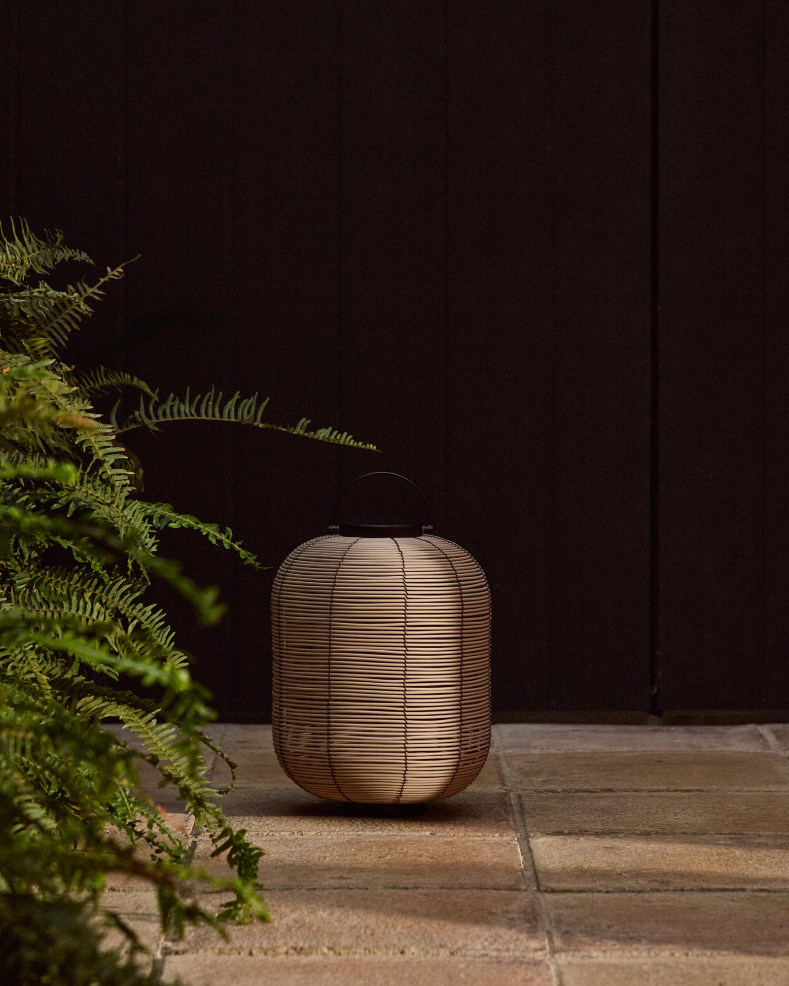 Kleine, stilvolle LED-Tischlampe Saranella aus hellem Rattan, perfekt für gemütliche Abende im Freien, erhältlich bei Kave Home.