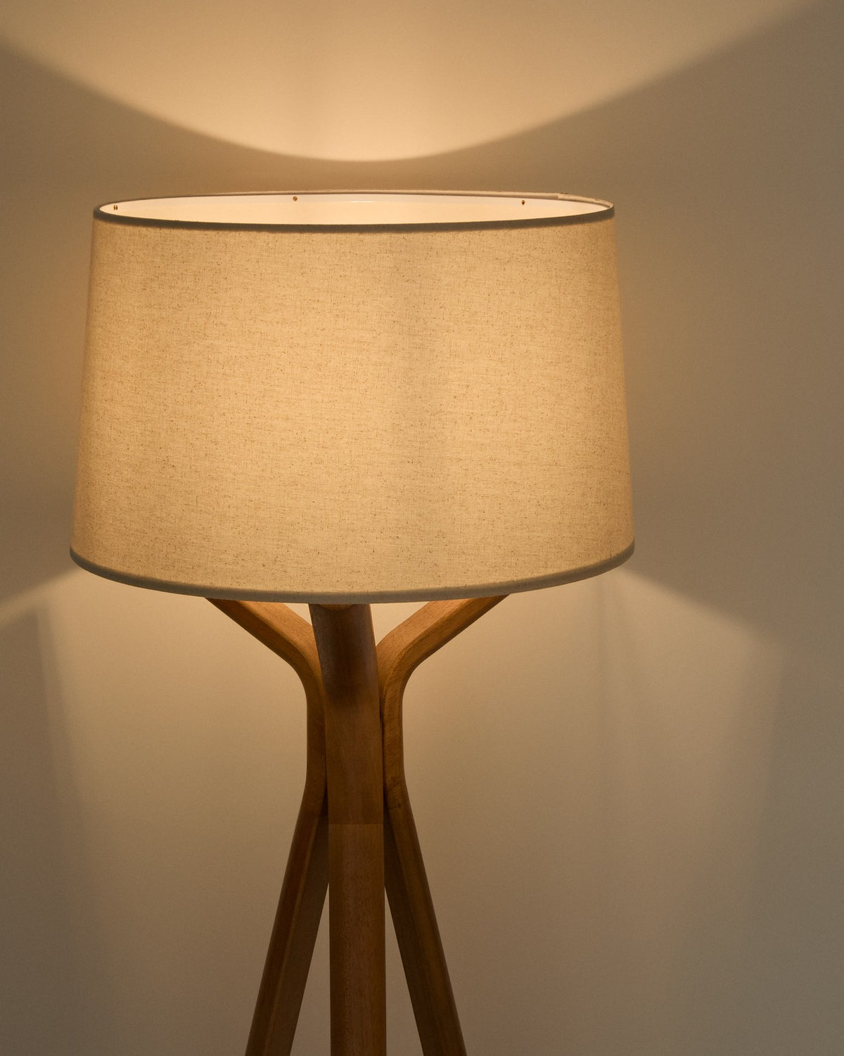 Stehlampe Ubira mit Rahmen und Sockel aus Eschenholz, Lampenschirm aus Leinen, stativförmige Basis, Fussschalter, Farbe Braun.