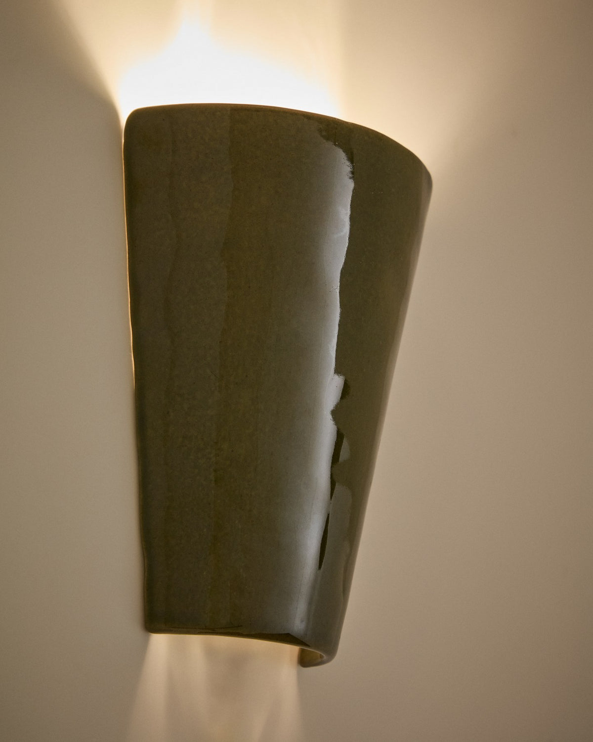 Wandleuchte Ceren von Kave Home aus grüner Keramik, kompakte Form mit klaren Linien, montiert an einer hellen Wand.