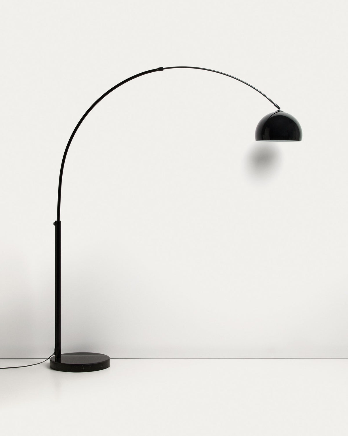Stehlampe Madali aus glänzend schwarzem Stahl mit gebogener Struktur und massivem Fuss aus schwarzem Marmor, schwenkbarer Lampenschirm.