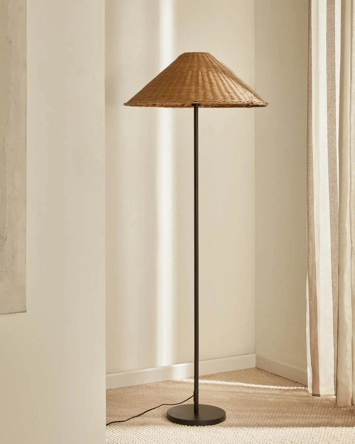 Elegante Urania Stehleuchte aus Rattan und Metall, schwarz lackiert, von Kave Home. Stilvolles Design für moderne Wohnräume.
