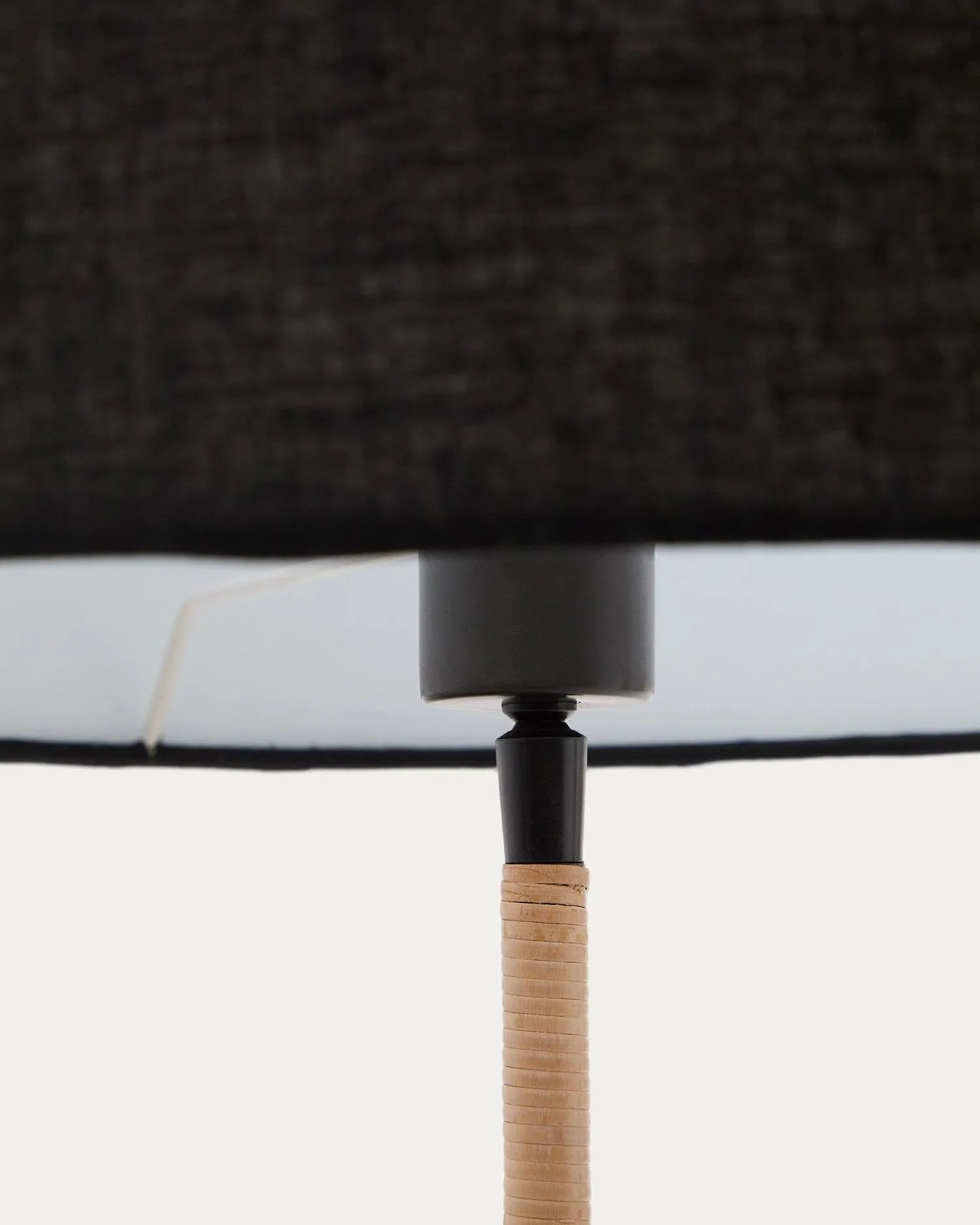 Elegante Stehlampe aus Metall und Rattan mit schwarzem Schirm, die Wärme und Stil in jeden Raum bringt.
