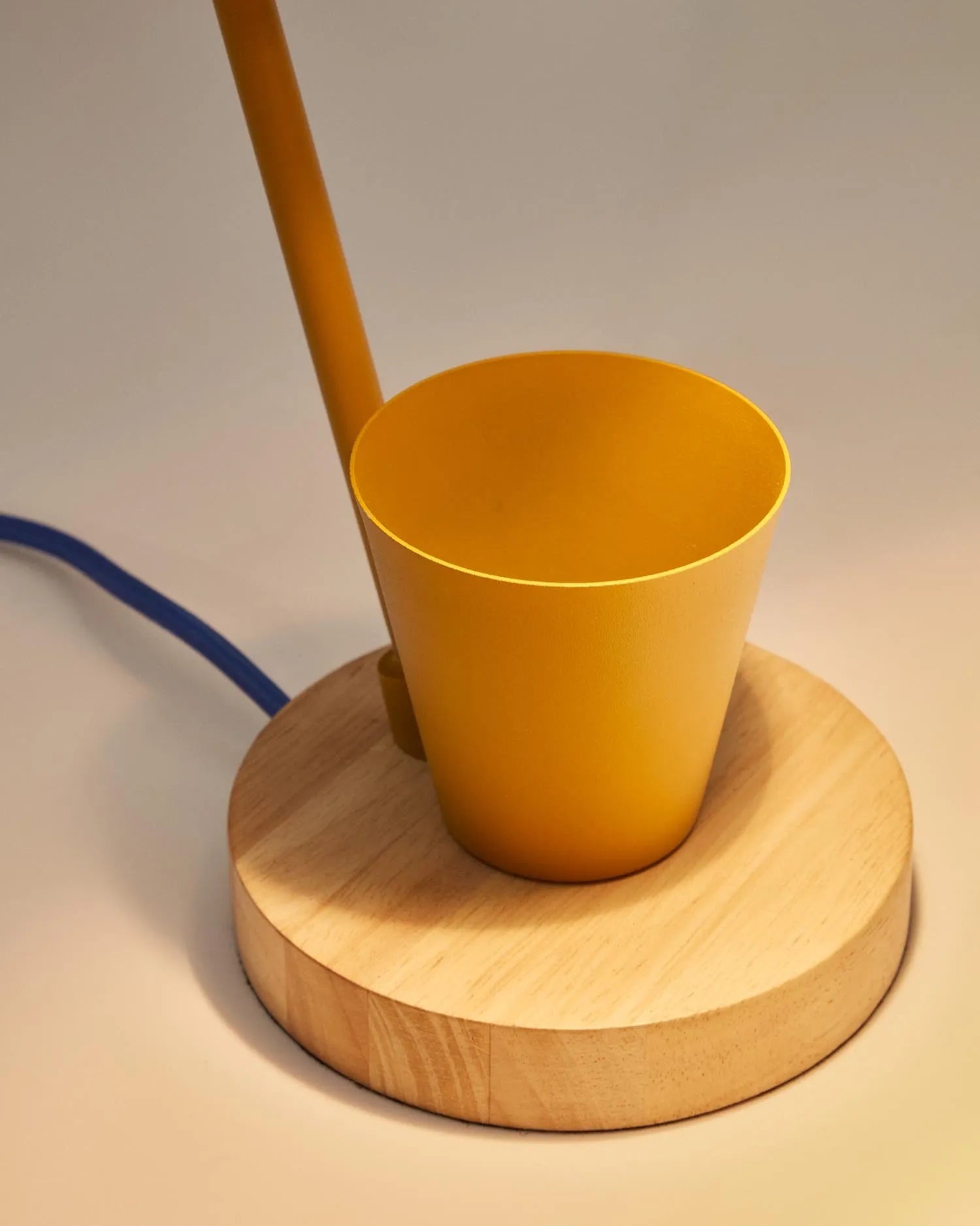 Die Katia Lampe vereint Holz und senffarbenes Metall zu einem stilvollen, funktionalen Design mit integriertem Stifthalter.