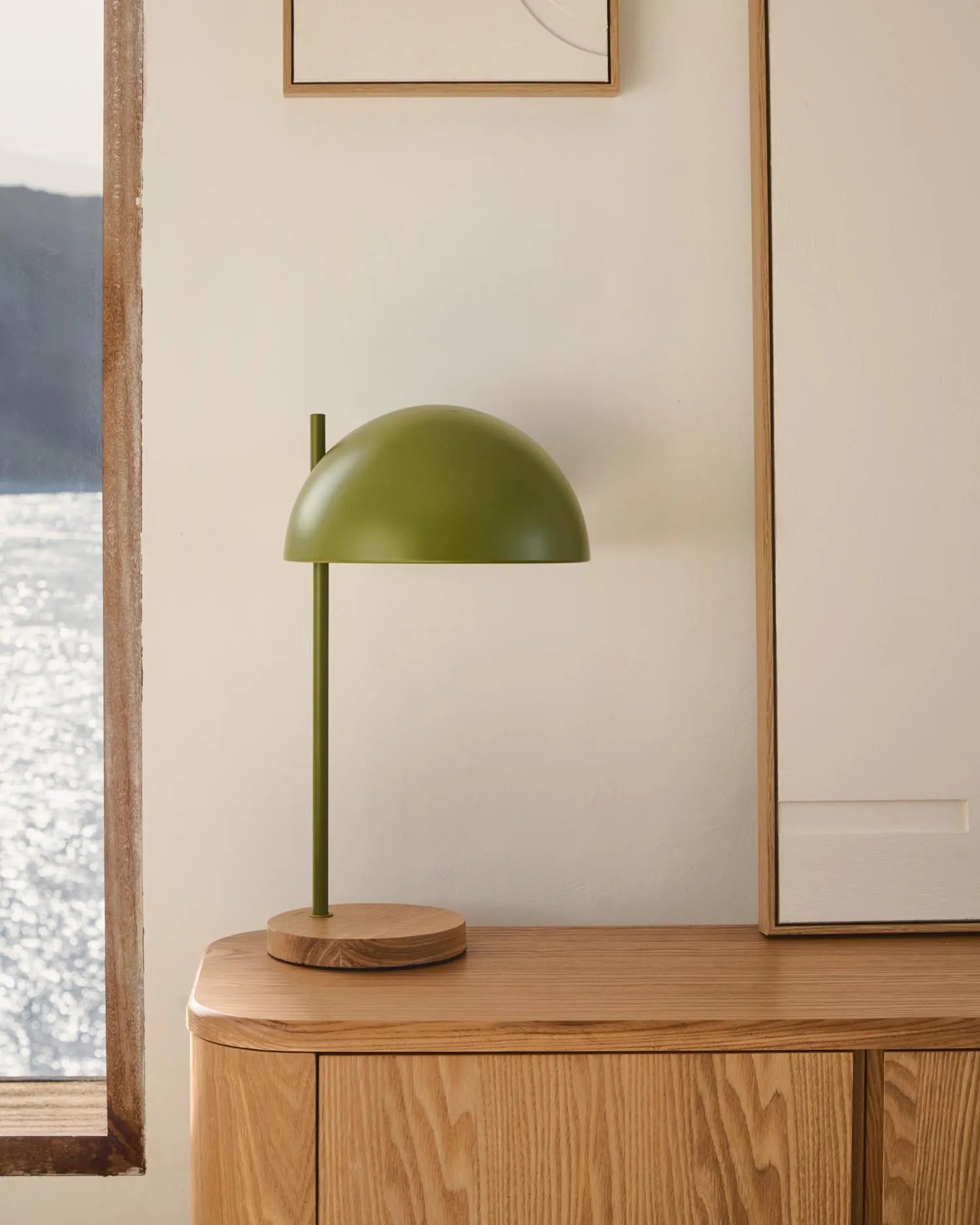 Die Catlar Tischlampe kombiniert Eschenholz und grünes Metall für ein modernes, elegantes Design, das jedem Raum Stil verleiht.