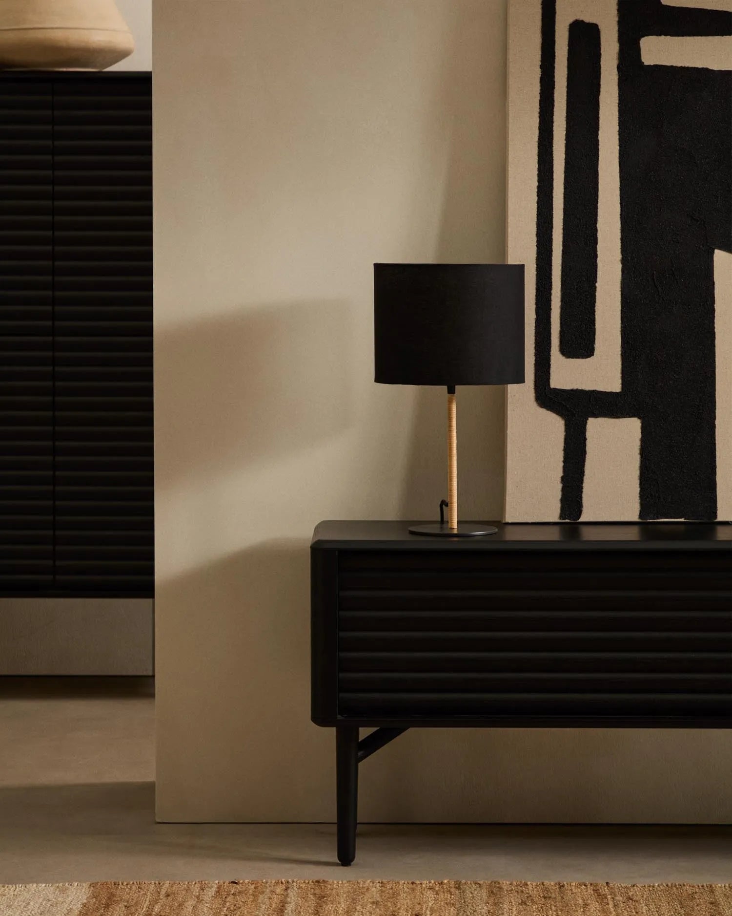 Die Pina Tischlampe vereint Metall, Rattan und Baumwolle zu einem eleganten, warmen Lichtakzent für jeden Raum.