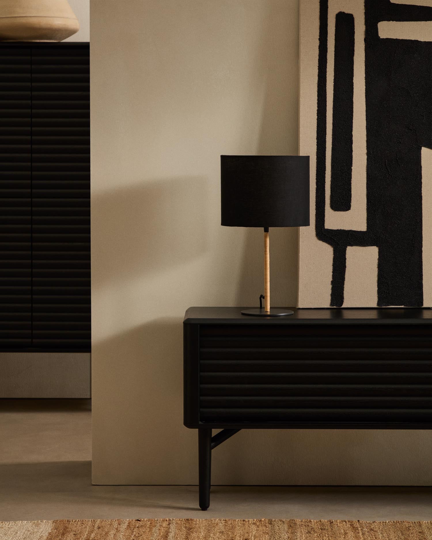 Die Pina Tischlampe vereint Metall, Rattan und Baumwolle zu einem eleganten, warmen Lichtakzent für jeden Raum.