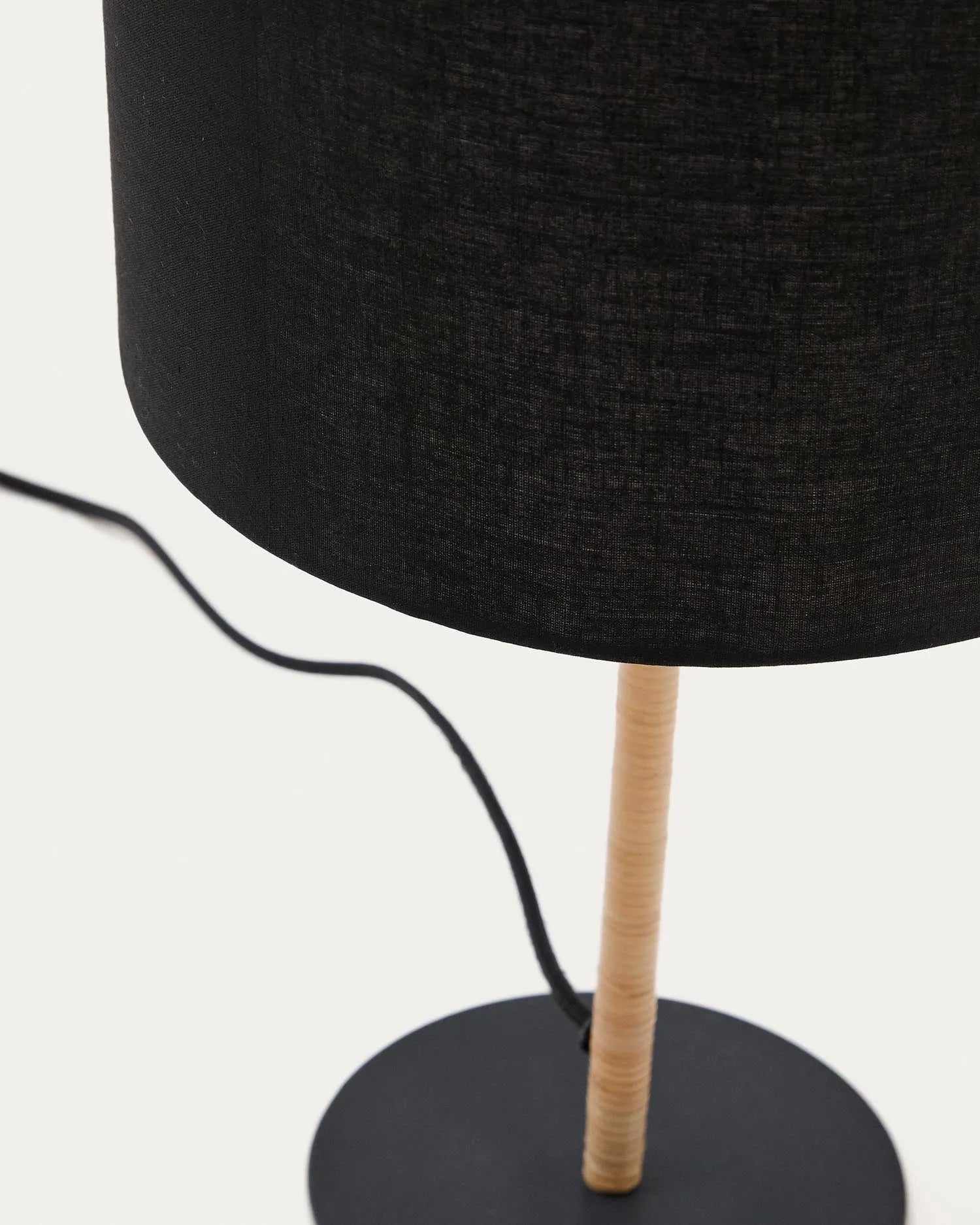 Die Pina Tischlampe vereint Metall, Rattan und Baumwolle zu einem eleganten, warmen Lichtakzent für jeden Raum.