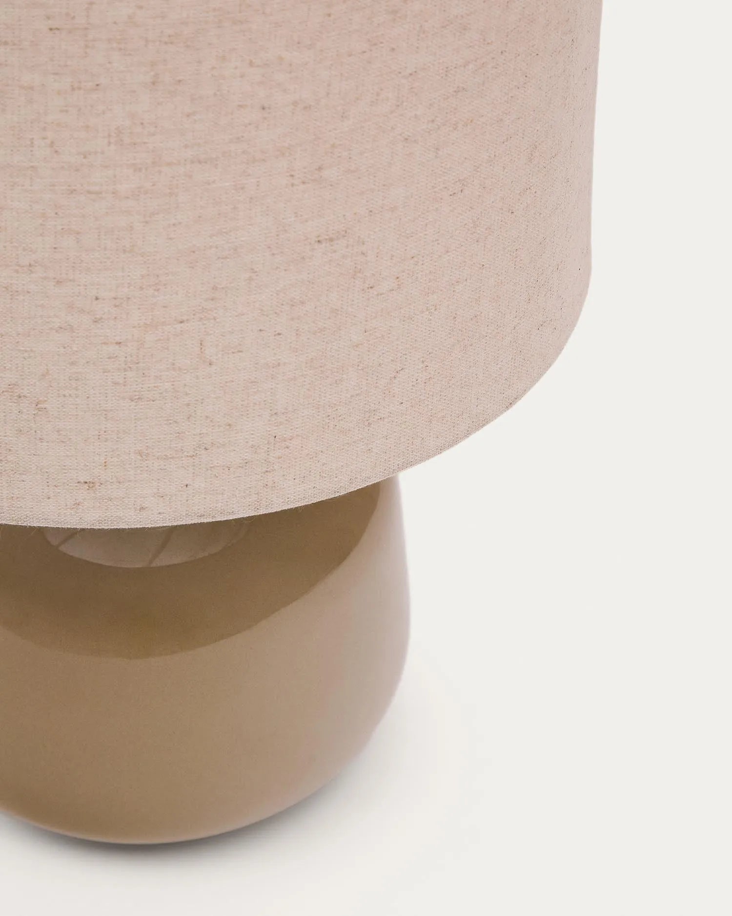 Elegante Tischleuchte Tay mit grünem Keramikfuß und beigem Leinenschirm, ideal für stilvolle Wohnräume von Kave Home.