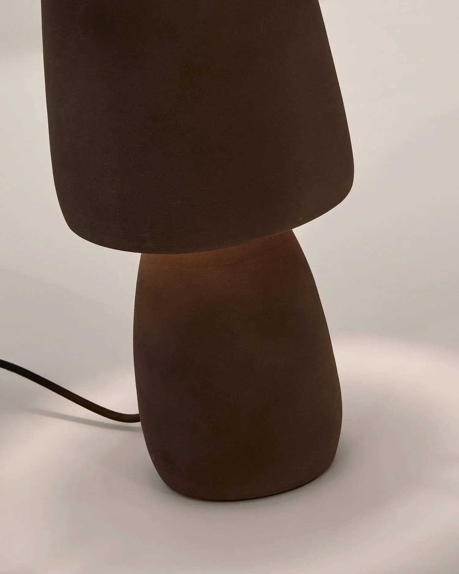 Die Tischleuchte Tandy aus brauner Terrakotta von Kave Home vereint natürliche Eleganz mit funktionalem Design und passt in jeden Raum.