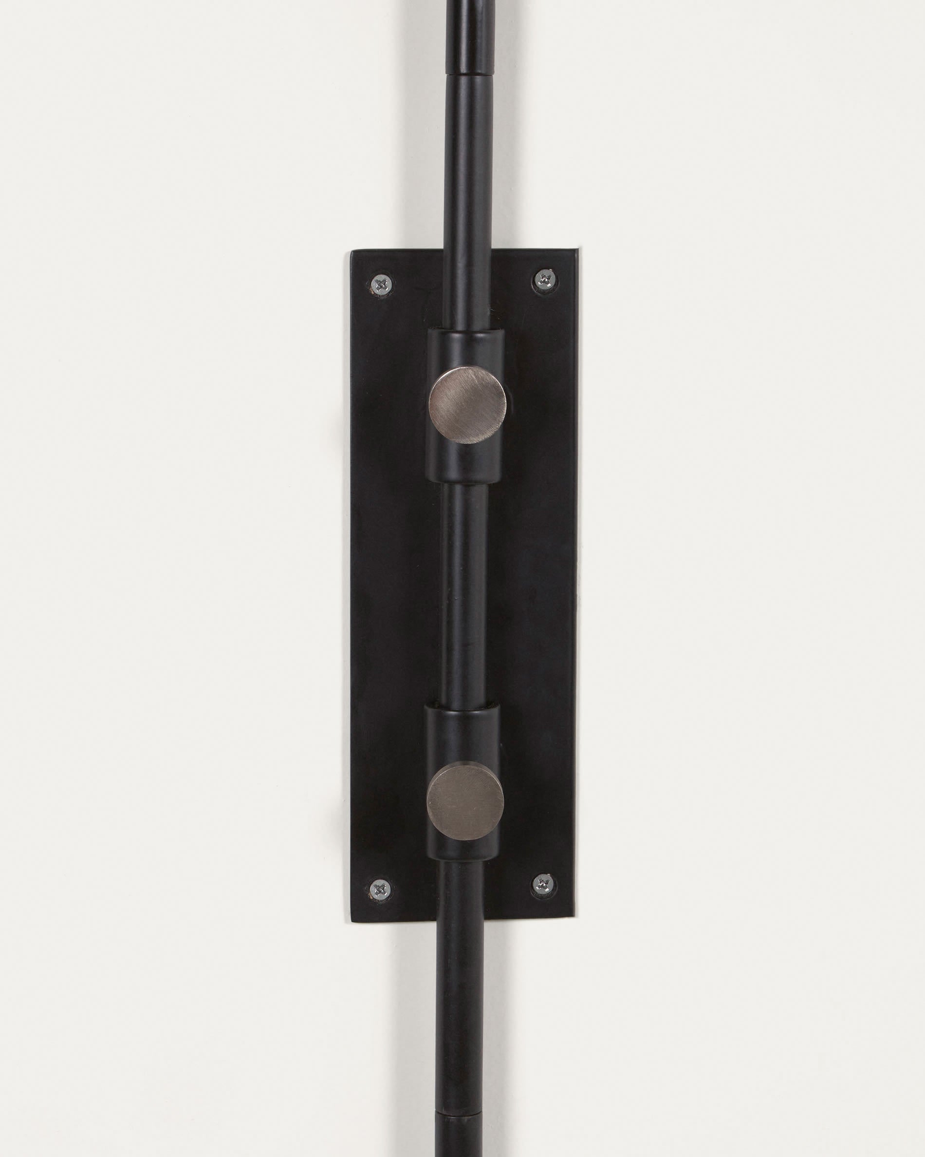 Die Eleazar Wandlampe von Kave Home kombiniert modernes Design mit schwarz lackiertem Metall für eine elegante Wandbeleuchtung.
