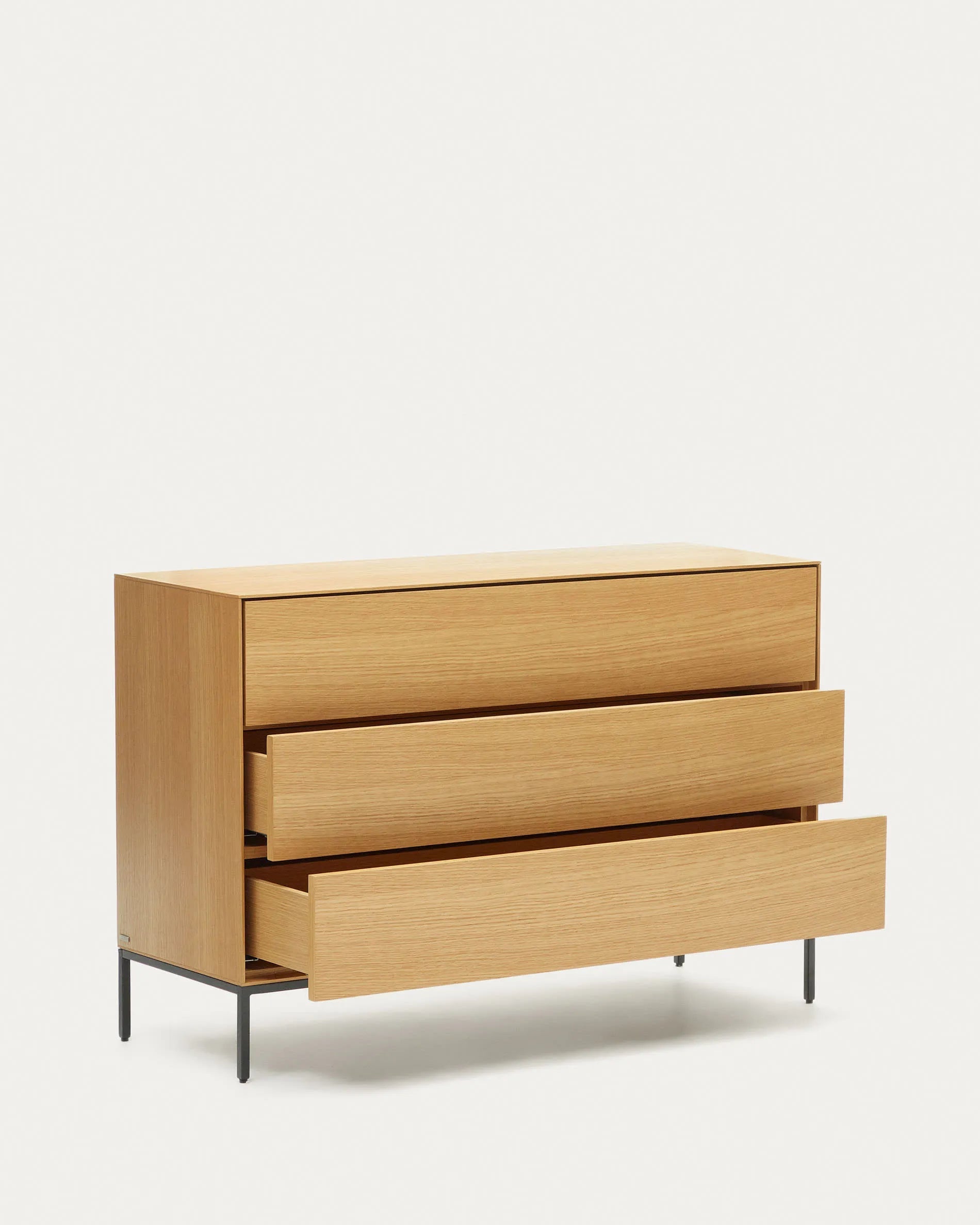 Die Vedrana Kommode aus Eichenfurnier mit schwarzen Stahlbeinen bietet 3 Schubladen und misst 110 x 75 cm. Modern und funktional.