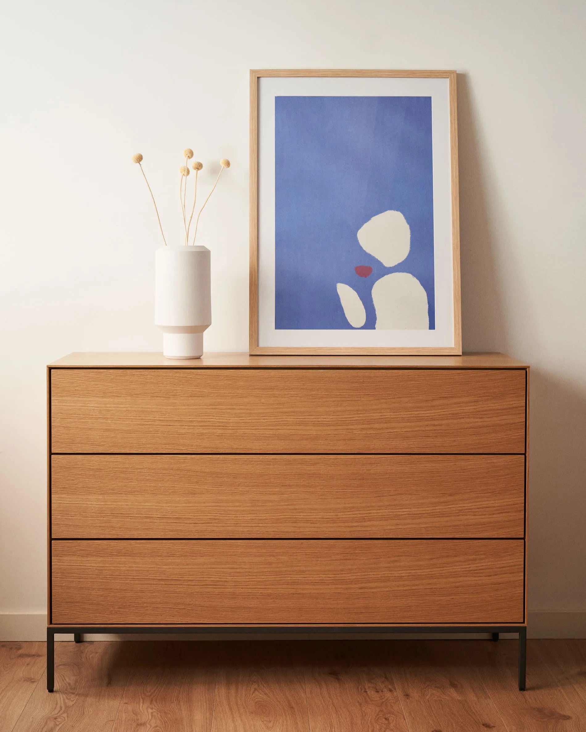 Die Vedrana Kommode aus Eichenfurnier mit schwarzen Stahlbeinen bietet 3 Schubladen und misst 110 x 75 cm. Modern und funktional.