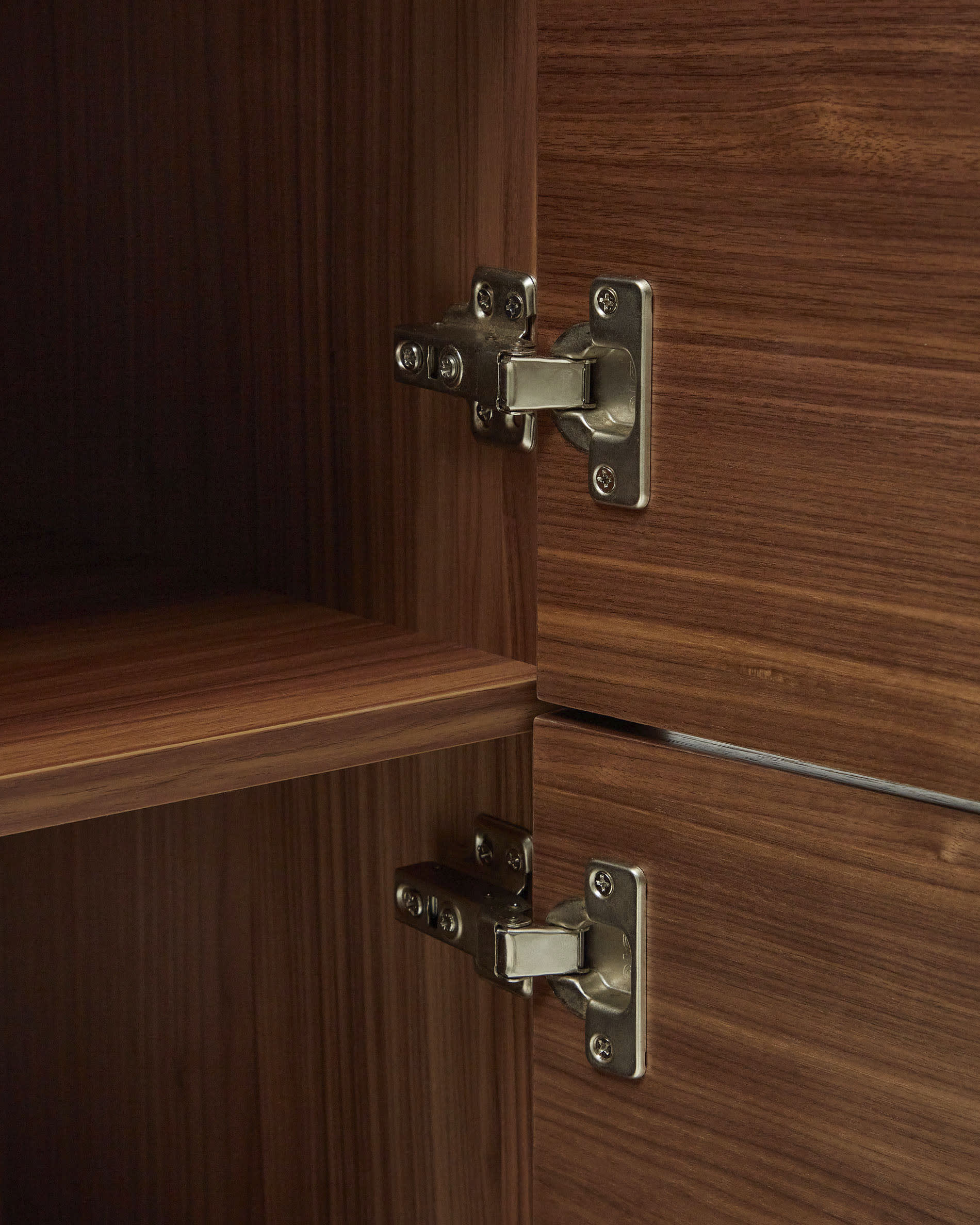 Das Vedrana Highboard kombiniert edles Nussholzfurnier mit schwarzen Stahlbeinen und bietet stilvolle Aufbewahrungslösungen.