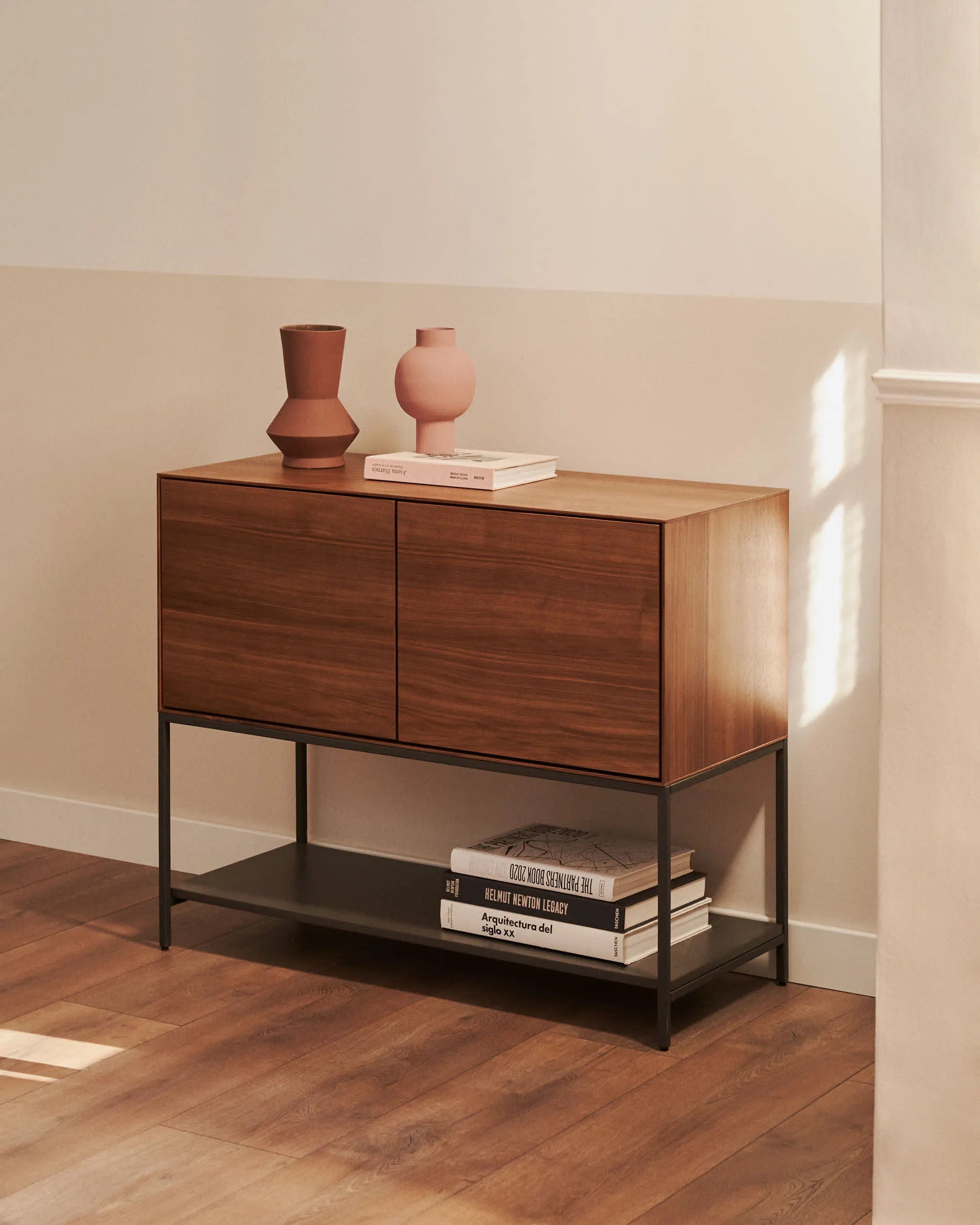 Das Vedrana Sideboard kombiniert edles Nussholzfurnier mit modernen schwarzen Stahlbeinen und bietet stilvollen Stauraum.