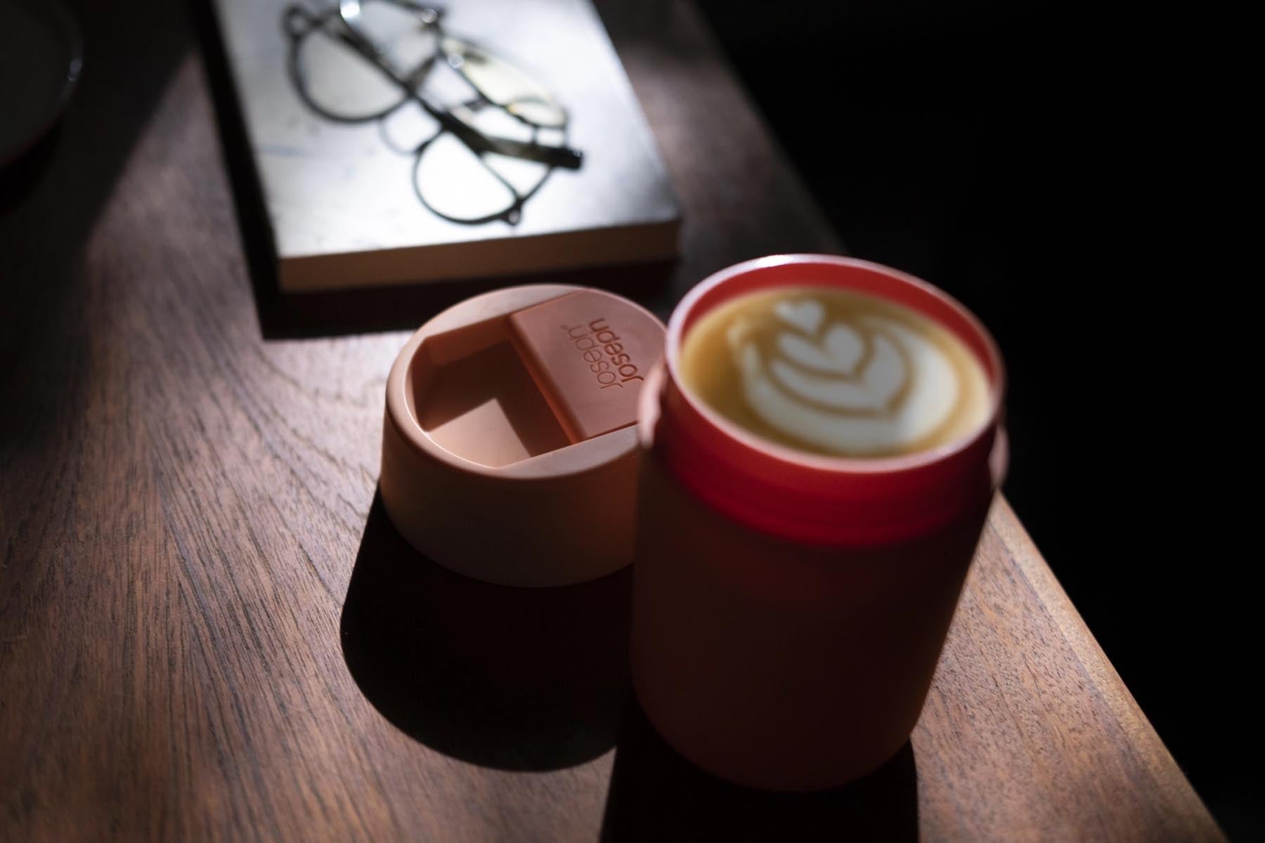 Stylischer Sipp Travel Mug in Koralle (340ml) von Joseph Joseph, ideal für unterwegs und perfekt für heiße Getränke.