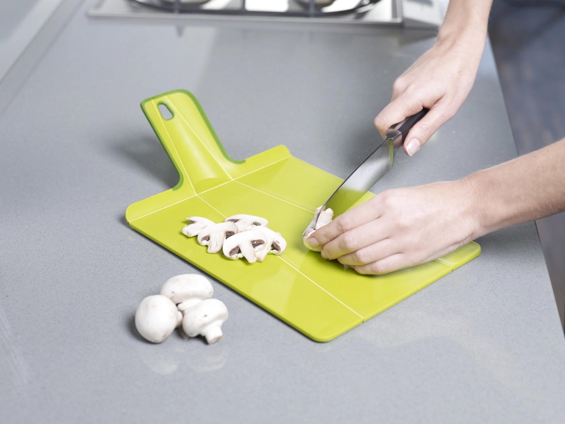 Chop2pot Plus in frischem Grün: praktisches Schneidebrett mit klappbaren Seiten für einfaches Umfüllen von Lebensmitteln.
