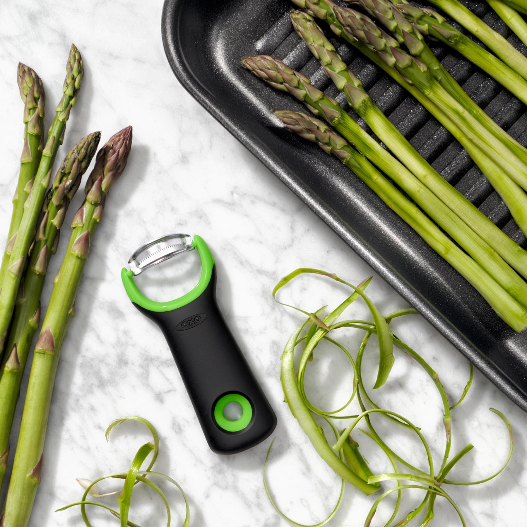 Der OXO GG Spargel Schäler in frischem Grün, ideal für müheloses Schälen von Spargel und anderen Gemüsesorten.