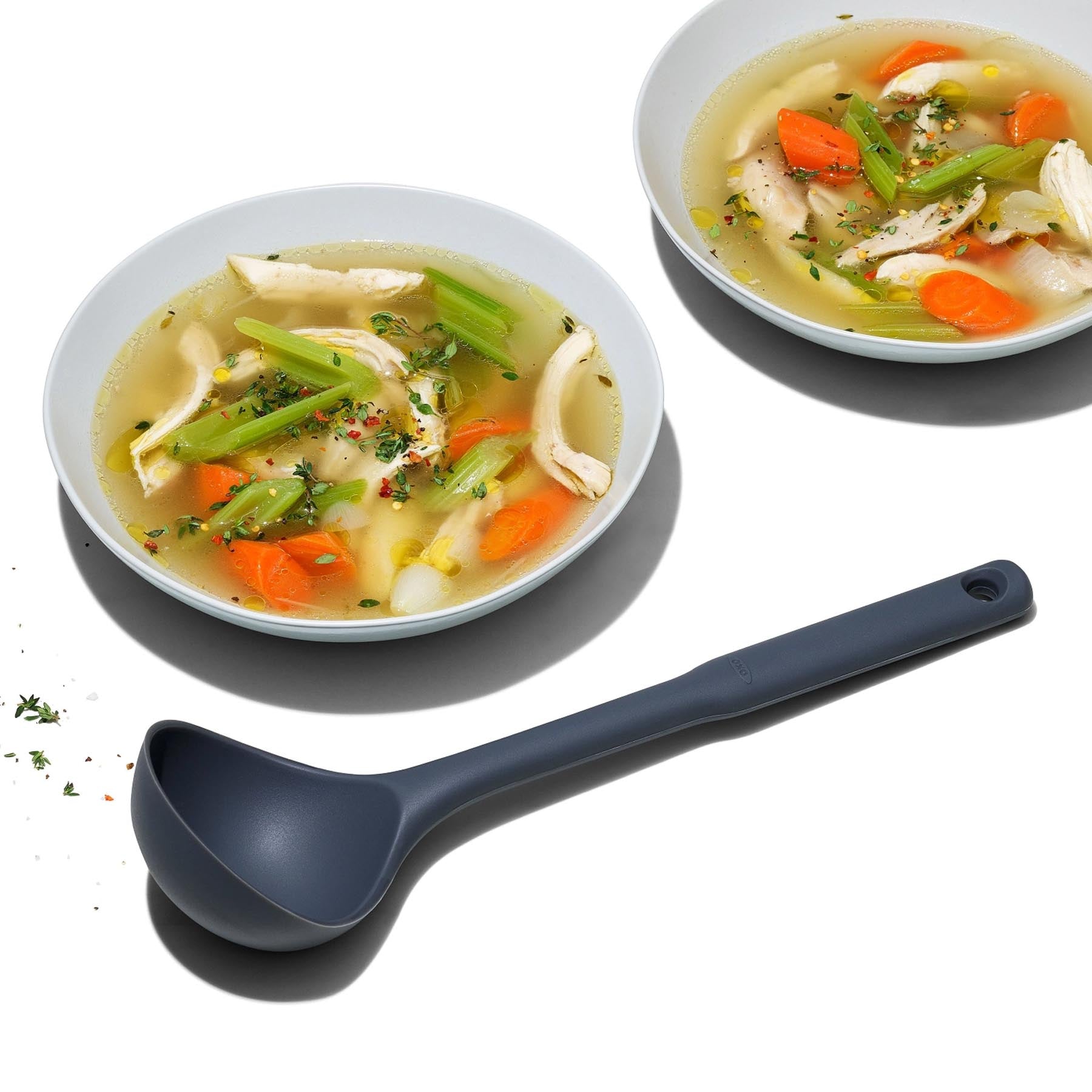 Großer Silikon-Schöpflöffel von OXO in elegantem Grau, ideal für das Servieren von Suppen und Eintöpfen, präsentiert in stilvollem Ambiente.