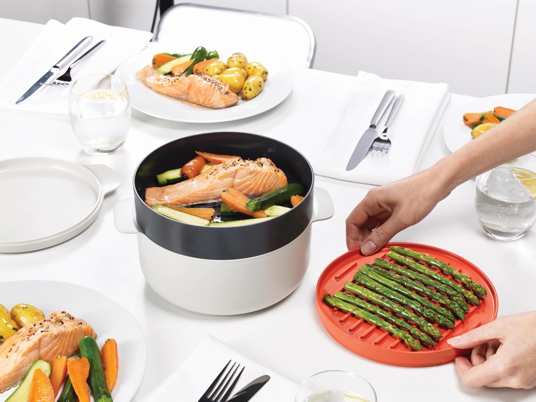 Praktisches 4er Set M-Cuisine Mikrowellenkocher in Grau und Orange von Joseph Joseph, ideal für schnelles und einfaches Kochen in der Mikrowelle.