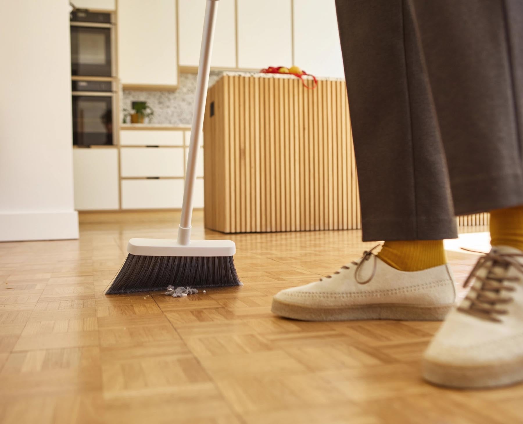 Eleganter CleanTech Besen in Steinfarbe mit Wandhalterung, perfekt für eine ordentliche und platzsparende Reinigungslösung.